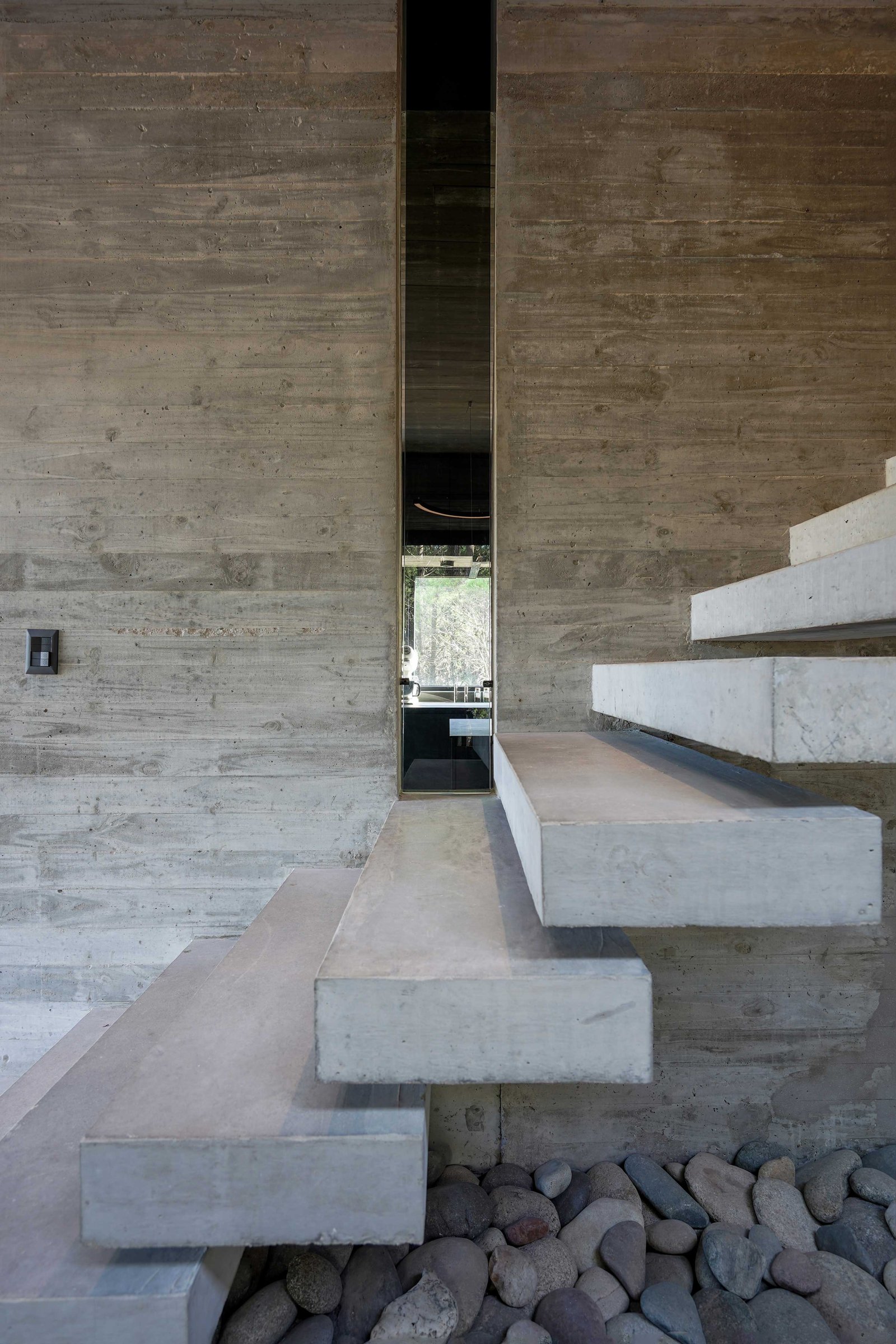Escalera flotante moderna de hormigón visto en interior brutalista — proyecto Casa 4H, por Besonías Almeida arquitectos, en X6VF+67