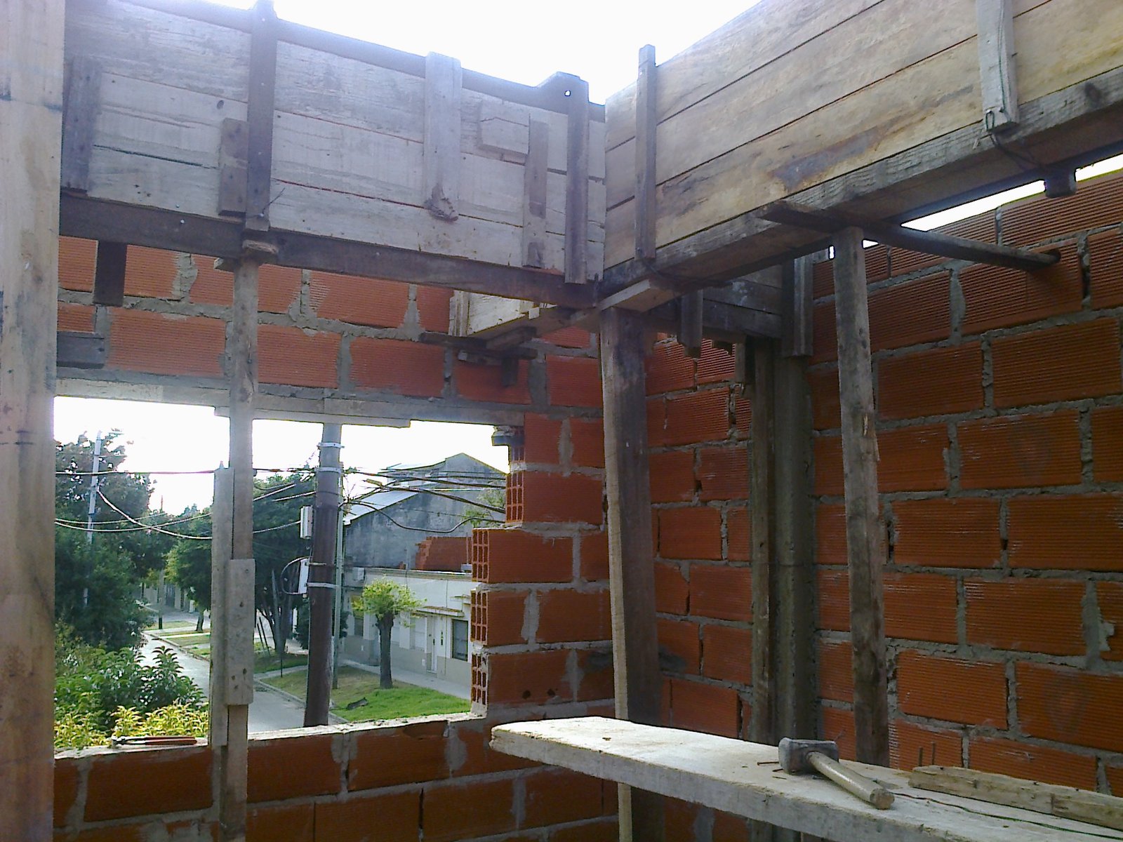 Construcción de interior con ladrillos expuestos y vigas de madera — proyecto Casa en Wilde, por Arquitecto Guido Niccoli, en Wilde