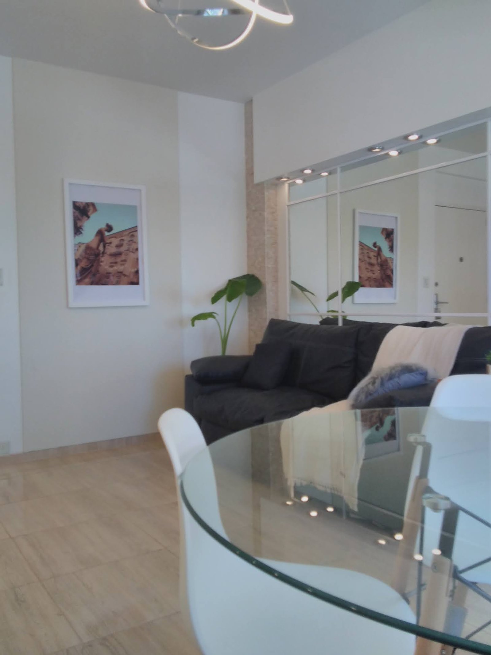 Living comedor moderno con mesa redonda de vidrio y sillas blancas — proyecto Vivienda Palermo , por HEIM ARQUITECTURA INTERIOR , en Palermo Hollywood