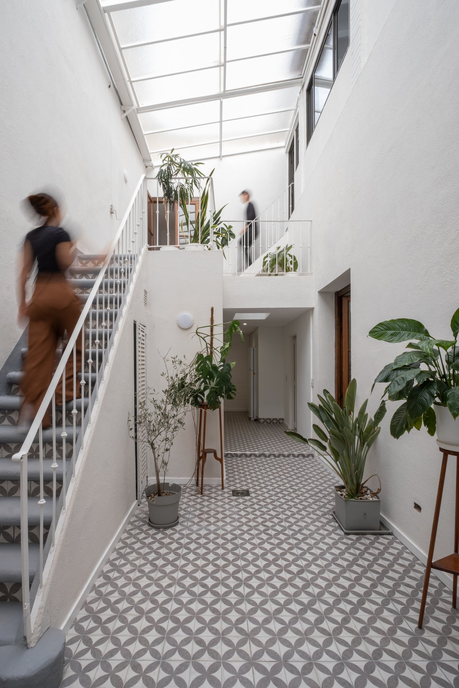 Interior moderno con escalera flotante y tragaluz — proyecto Casa Patio, por Herrera Ungaro, en San Cristóbal