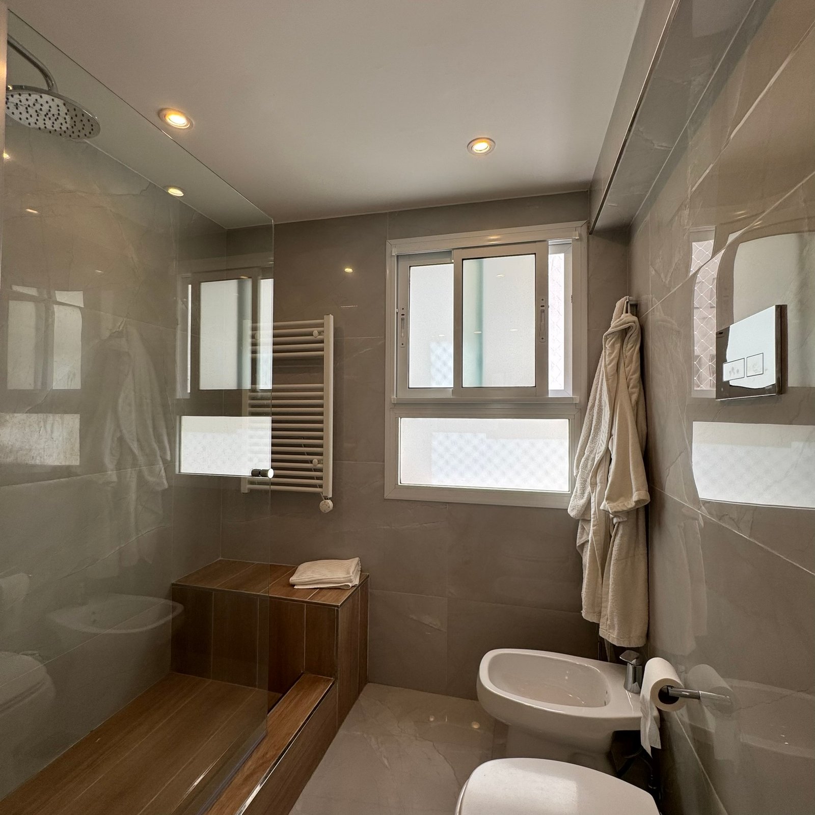Baño moderno con bañera exenta y almacenamiento de madera — proyecto Las Heras, por MDBK Arquitectura, en Palermo