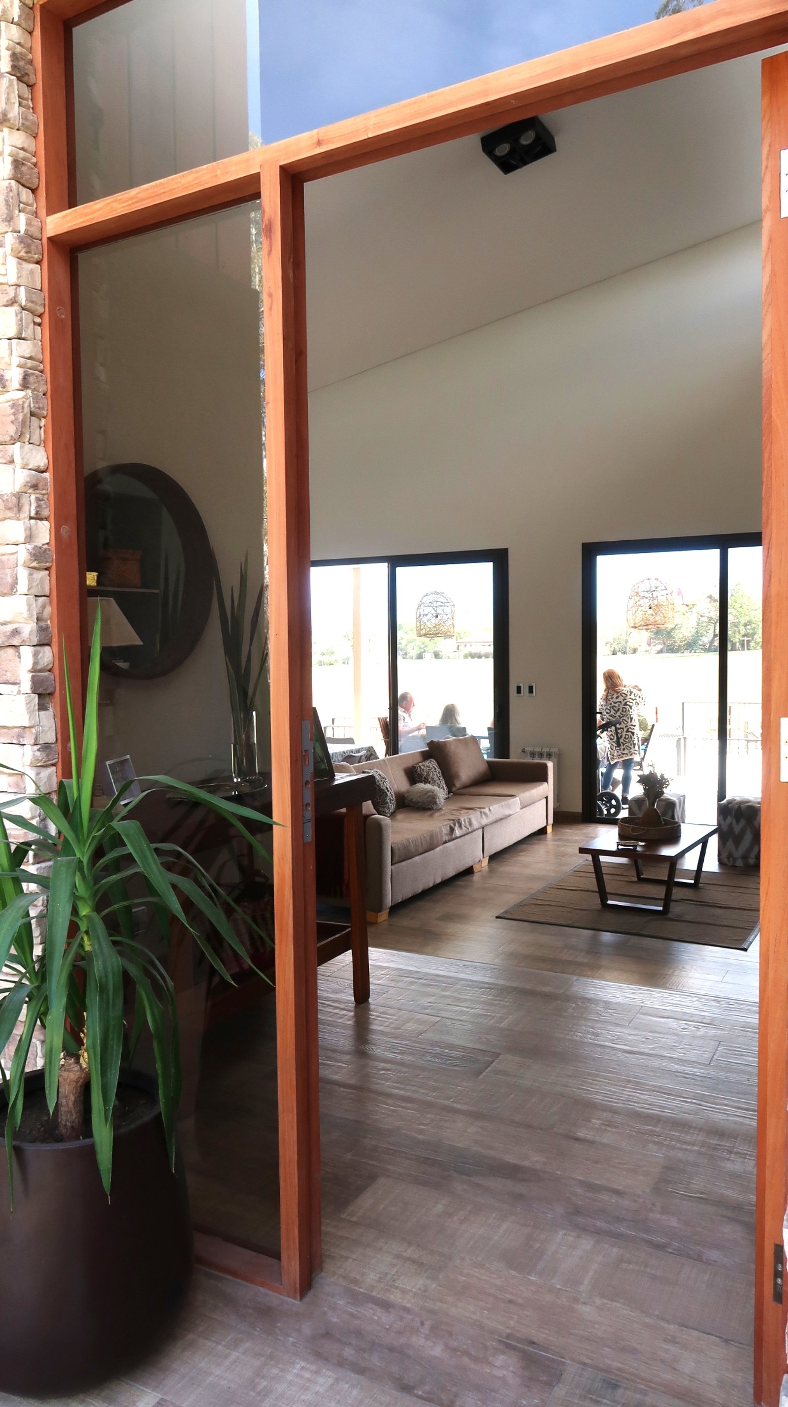 Living moderno con vista al exterior y sofá amplio — proyecto Casa La Paz, por Luciana González Anderson, en Salta