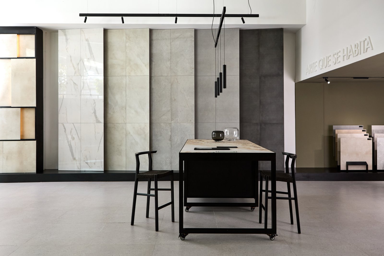 Sala de exposición moderna con baldosas de gran formato y mobiliario industrial — proyecto Showroom, por San Lorenzo Design, en Buenos Aires