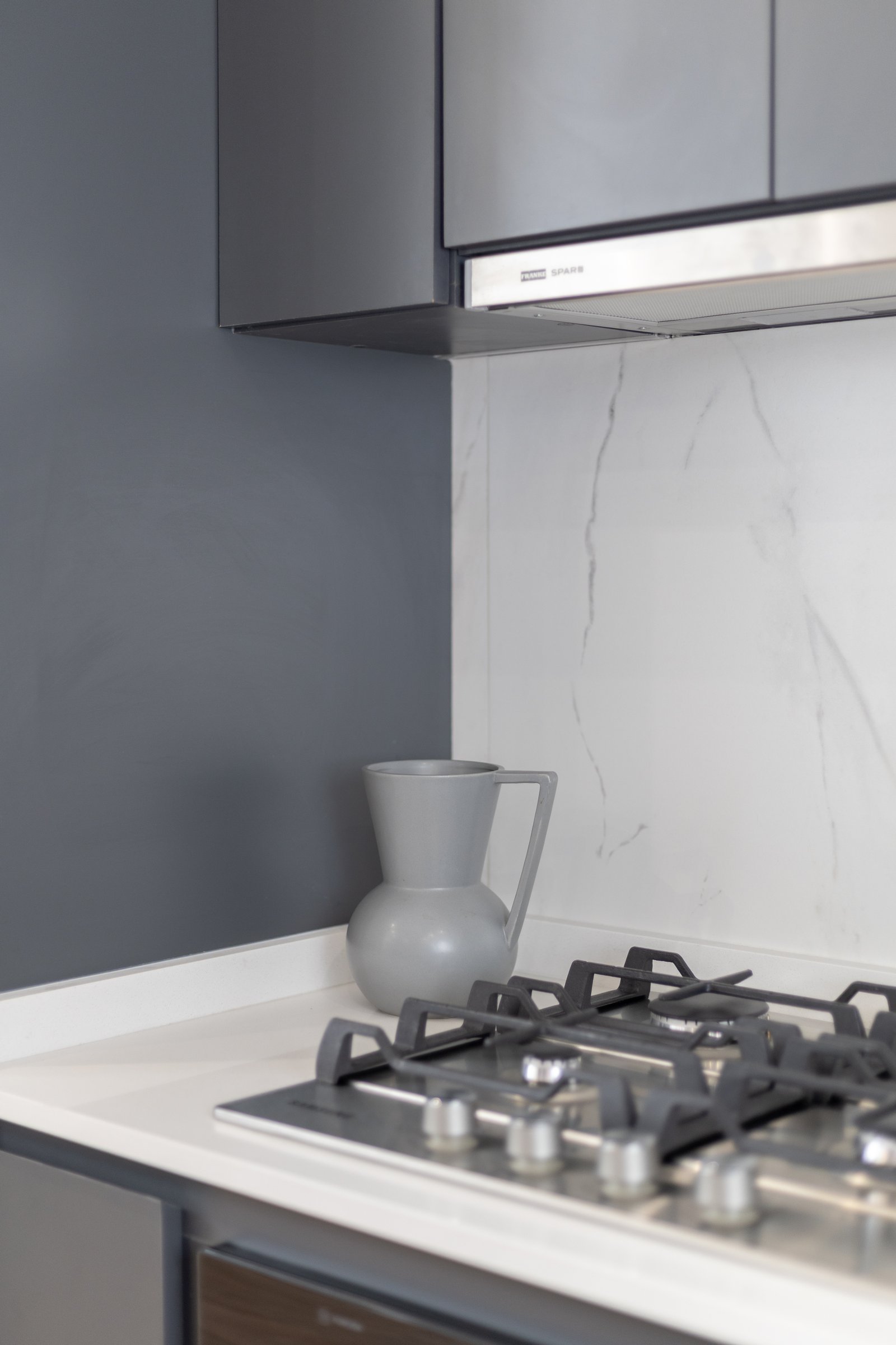 Cocina moderna con gabinetes grises y detalles en mármol — proyecto Boedo, por Martina Kleinert, en Boedo
