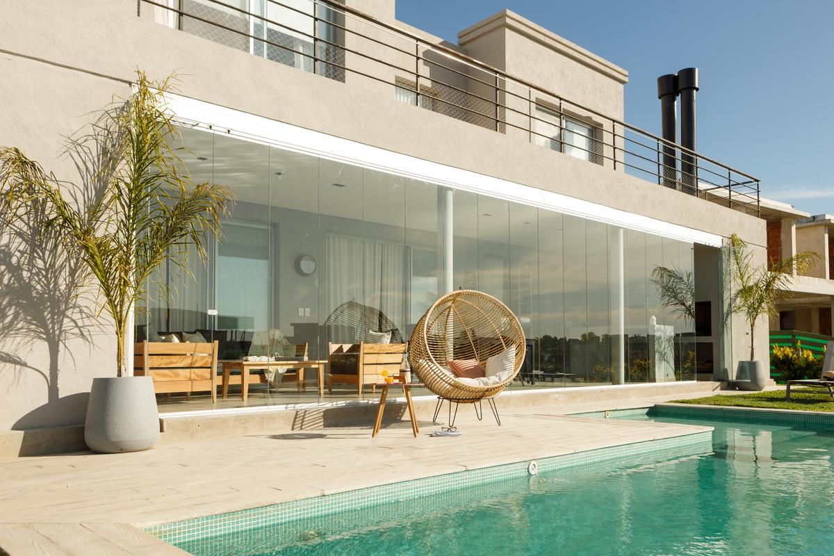 Fachada moderna com piscina e cadeira suspensa de rattan — projeto TOLDER - CERRAMIENTOS, por Argentina en Obra 2024, em Rincón de Milberg