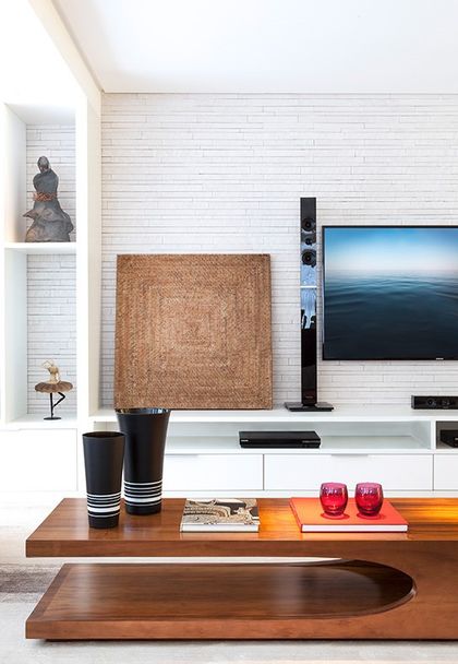 Living moderno con TV empotrada, mueble madera y detalles decorativos — proyecto Apartamento 180m Boa Viagem, por André Caricio