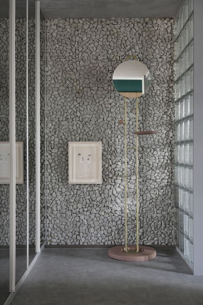 Baño minimalista con revestimiento de piedra gris y espejo circular — proyecto Casa COR 2019, por Studio Ro-ca