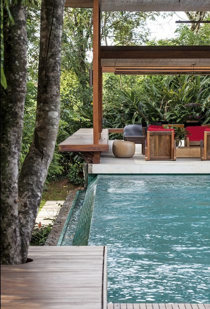 Pileta con deck de madera y pergola en selva tropical — proyecto Residência GS, por Gil Fialho