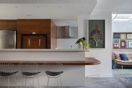 Cocina moderna con isla de madera y taburetes metálicos diseño — proyecto Casa Jardim Guanabara, por Amanda Miranda