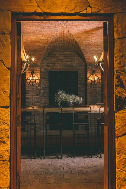 Comedor industrial con hogar de ladrillo visto y doble altura iluminado — proyecto Rosell Boher Lodge , por Estudio Du 