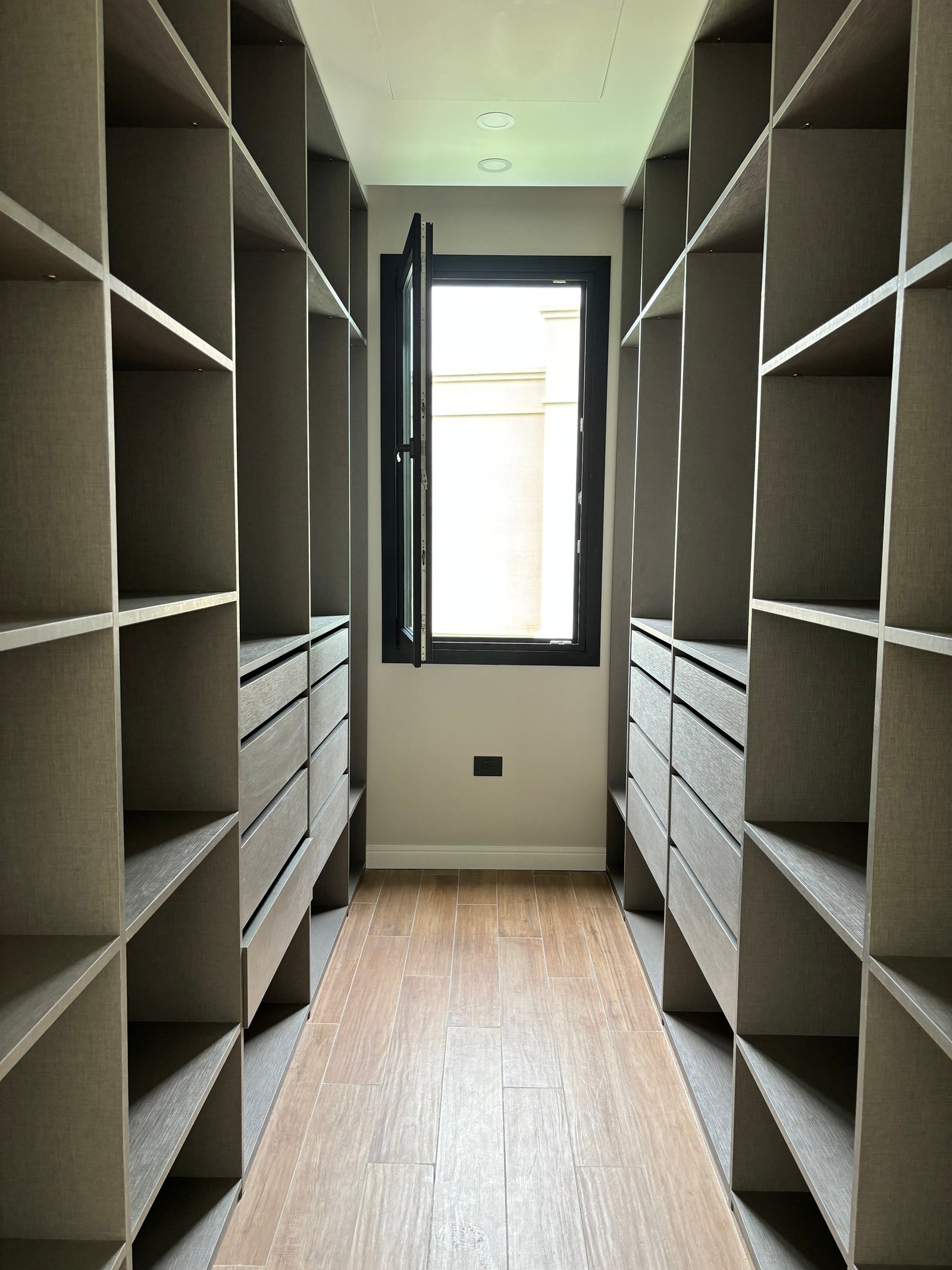 closet moderno com prateleiras e gavetas embutidas — projeto LOTE 020, por DIKKA Arquitecta, em San Vicente