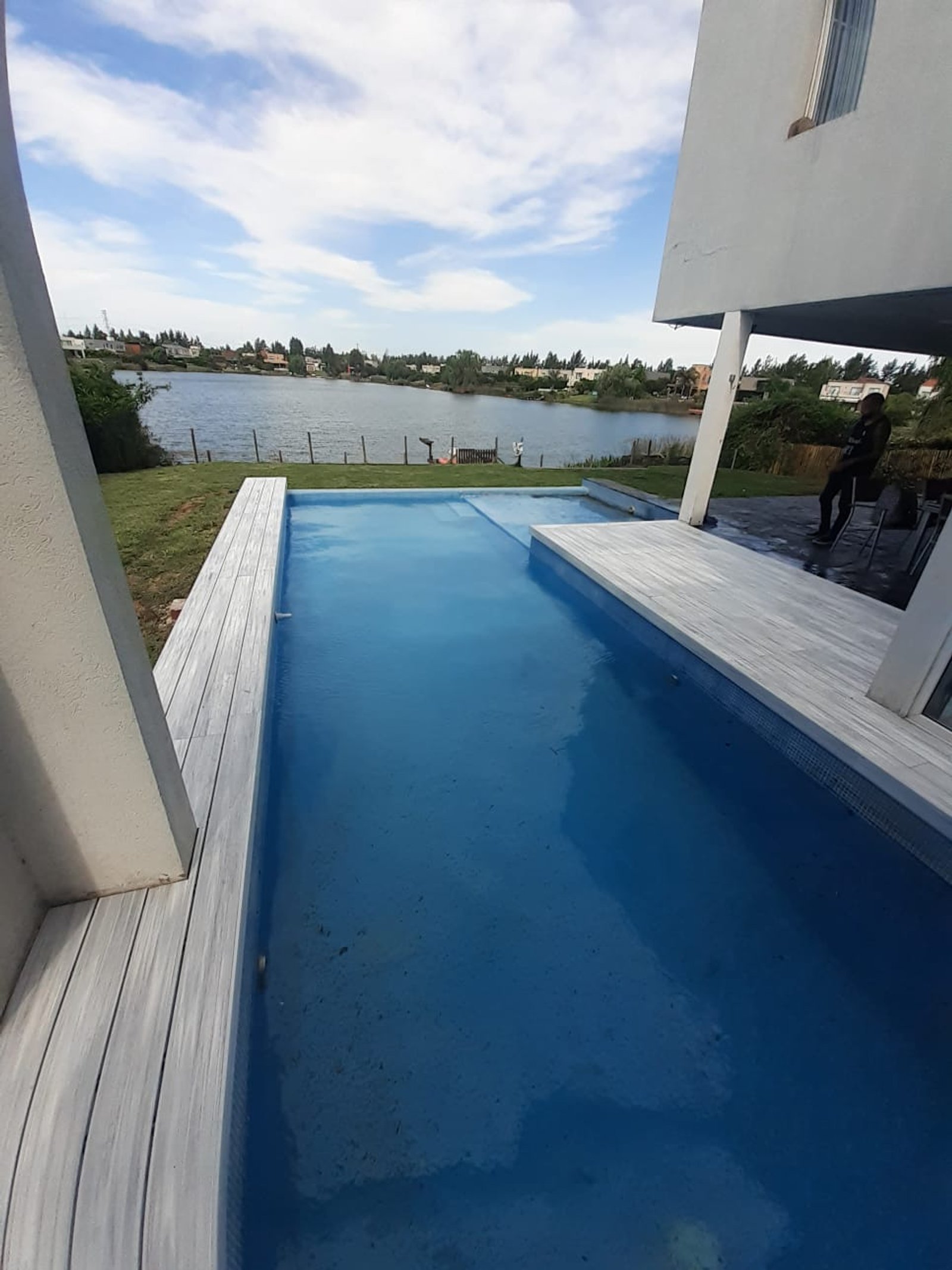 Piscina moderna con deck y vista al lago — proyecto Outdoor, por The Flooring Company