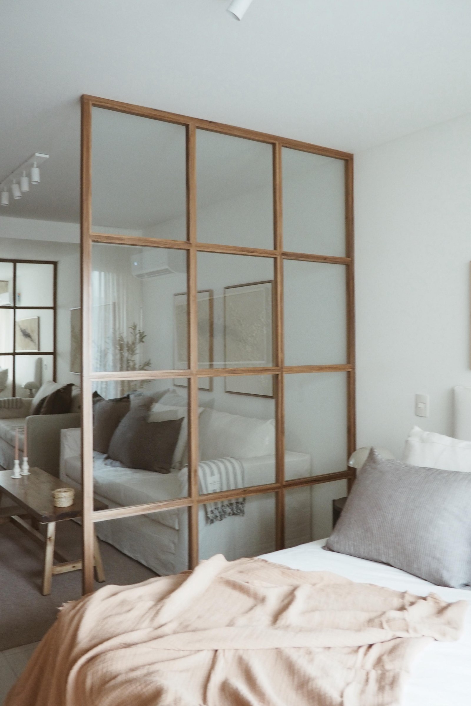 Ambiente moderno con separador de vidrio y muebles neutros — proyecto MIGUELETES, por APATHEIA, en Buenos Aires