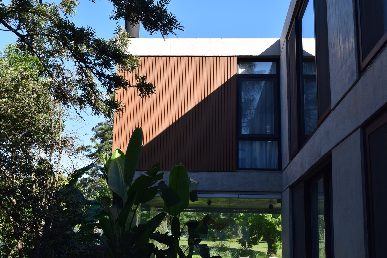 fachada moderna de madeira e vidro — projeto Obra Highland Park, por lifecycle, em Pilar
