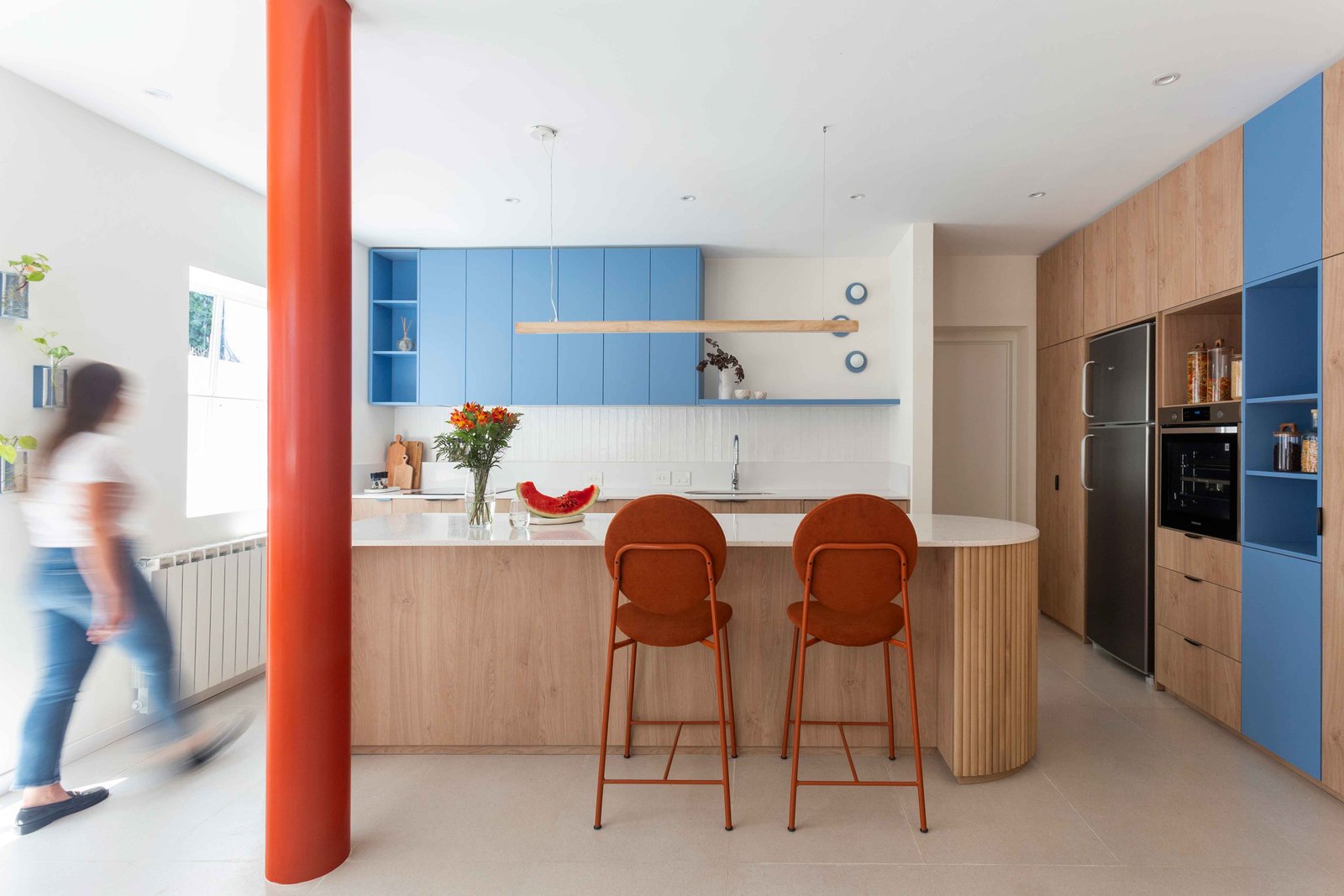 Cocina moderna con isla, bancos naranjas y columna naranja vibrante — proyecto Grecia, por Bouré Studio, en Núñez