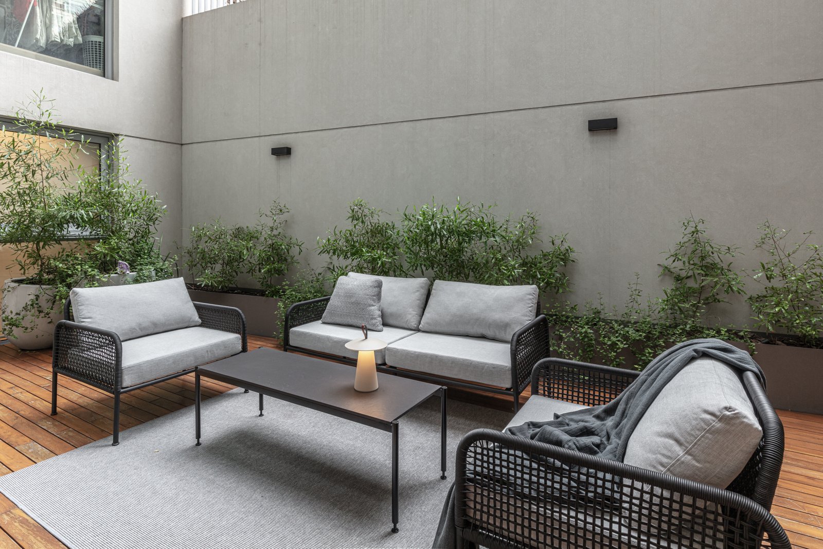 Pátio moderno com sofá modular, mesa e deck de madeira — projeto Donna Fiore | Sobrio & sofisticado | Sober & Sophisticated | Lucia Quinteros, por Ren Studio, em Provincia de Bueno