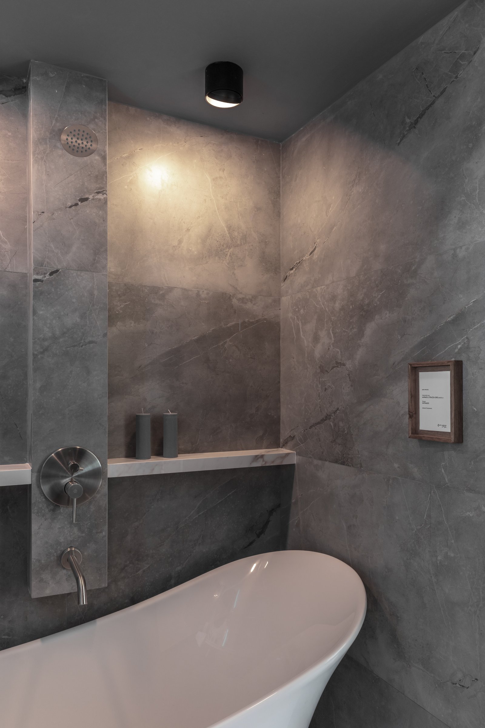 Baño moderno con bañera exenta y revestimiento de piedra gris — proyecto Claudio Wertheim + Virginia Ortiz, por San Lorenzo Design, en Cam. de los Remeros 1585