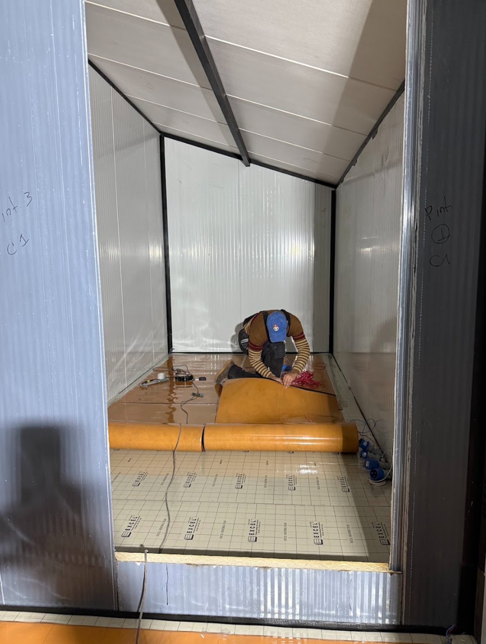 Persona instalando piso en construcción modular interior — proyecto Casa Modular, por HEAT LIFE, en Buenos Aires
