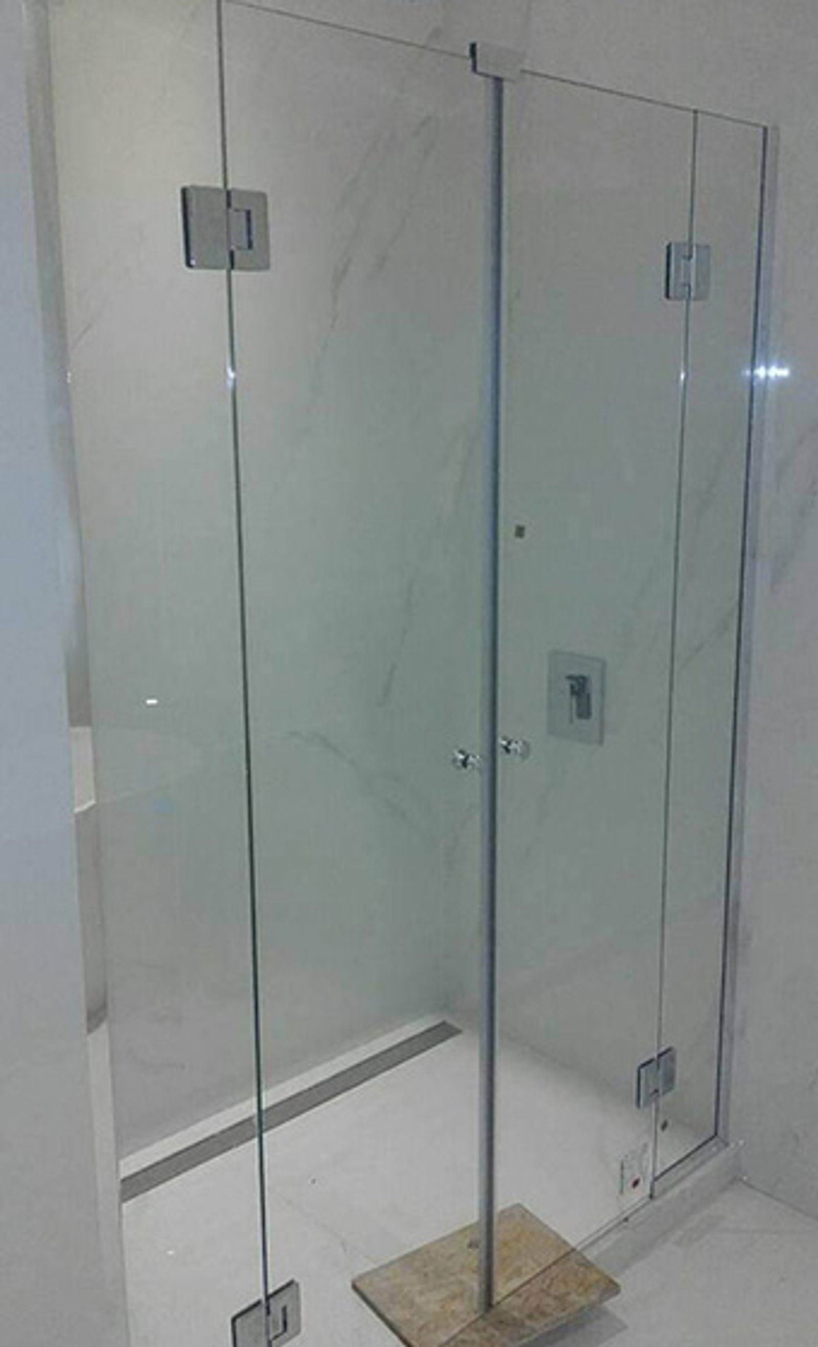 Banheiro moderno com box de vidro sem moldura e revestimento de mármore — projeto Mampara 8mm templada, por Cristalcenter, em Buenos Aires