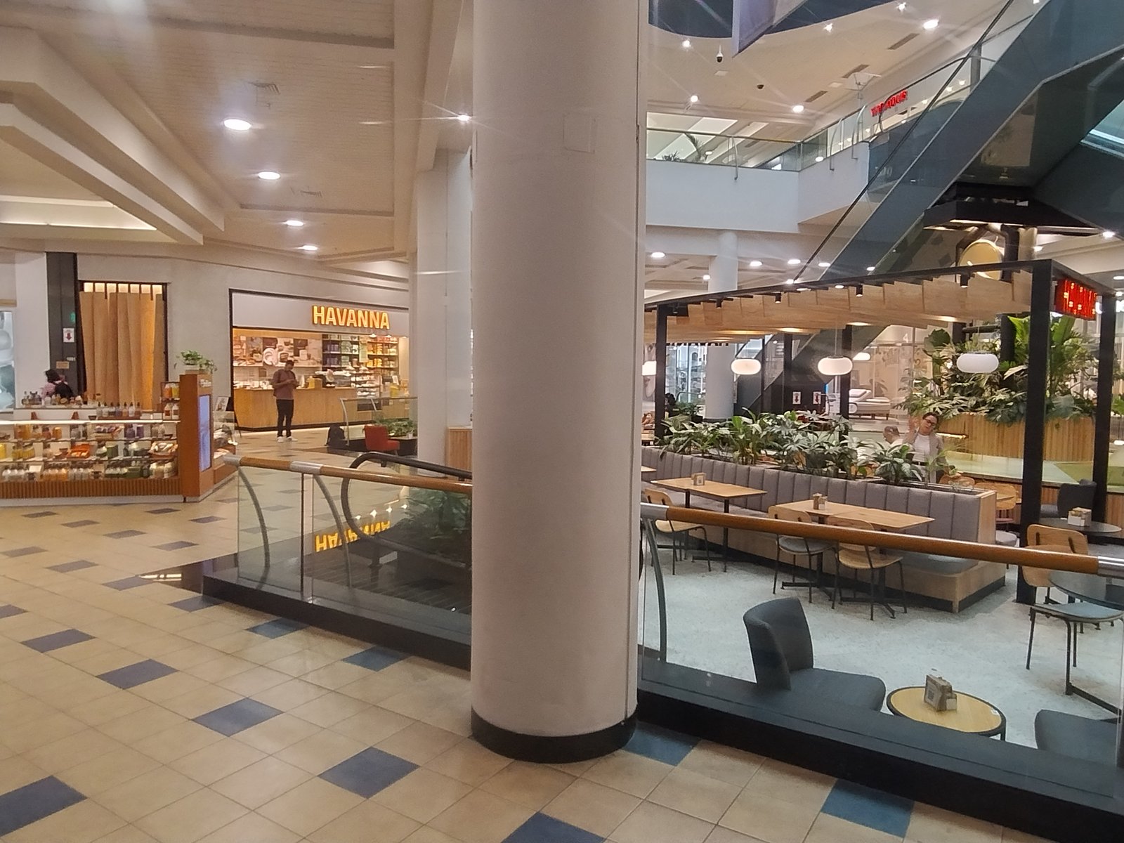 Interior de shopping center com coluna central e lojas — projeto Havanna Plaza Oeste Shopping, por COMOTTO - SOMMER  - ARQUITECTOS, em Blvd. Juan Manuel de Rosas 658