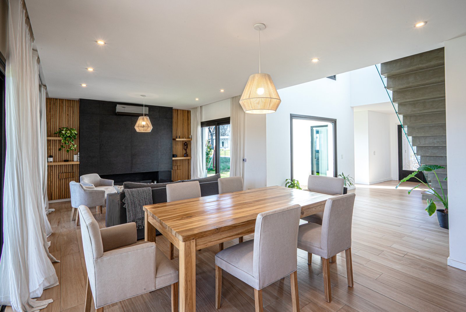 Comedor y living integrados, madera natural, iluminación cálida — proyecto SS45, por EZ architects, en Pilar