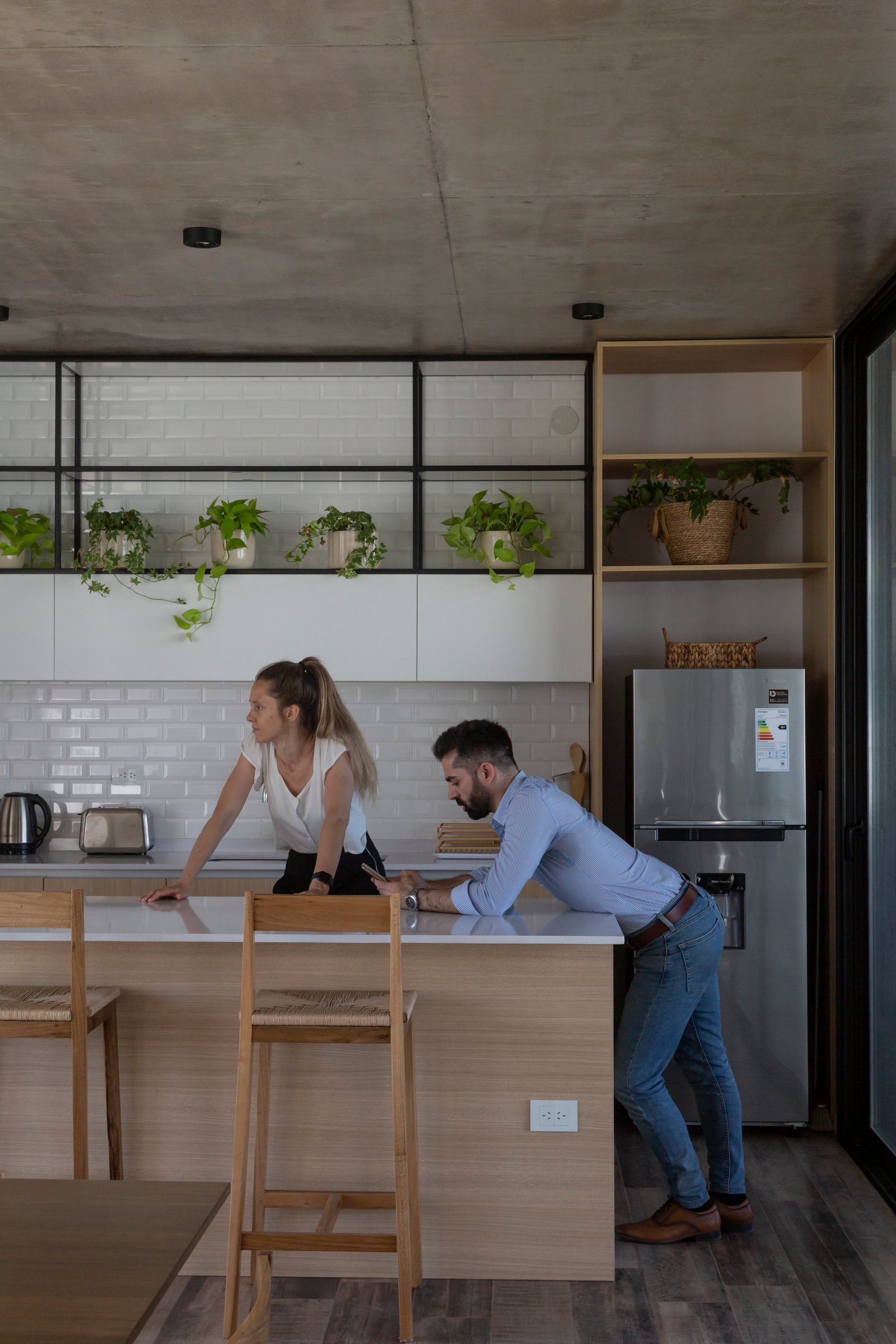 Cocina moderna con isla, techos de hormigón y estanterías abiertas — proyecto Casa Cruz , por Grupo CRBN, en B2812 Exaltación de la Cruz