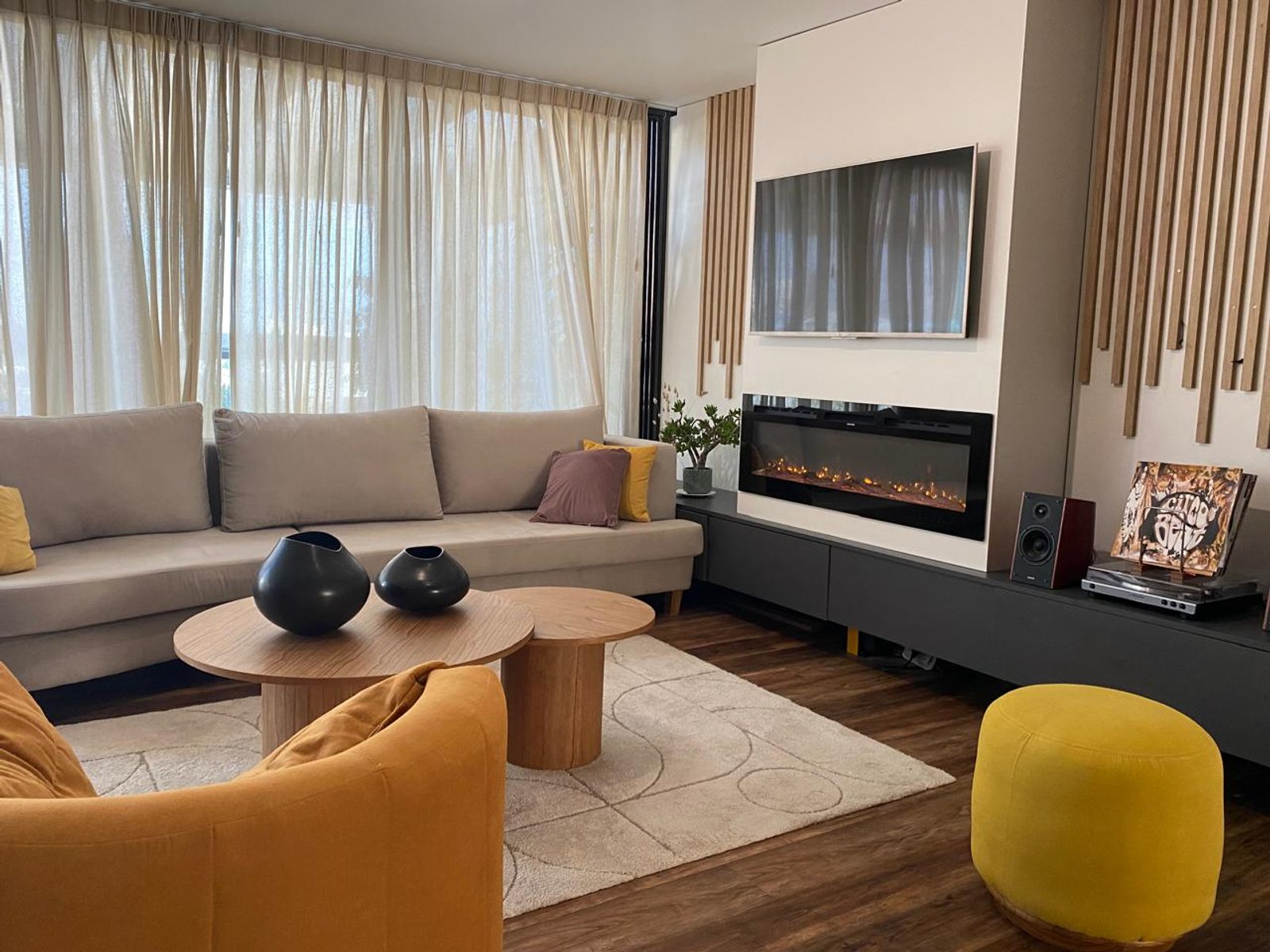 Sala de estar moderna com cortinas amplas e detalhes em madeira — projeto Proyecto 60, por Momas Interiores, em La Plata