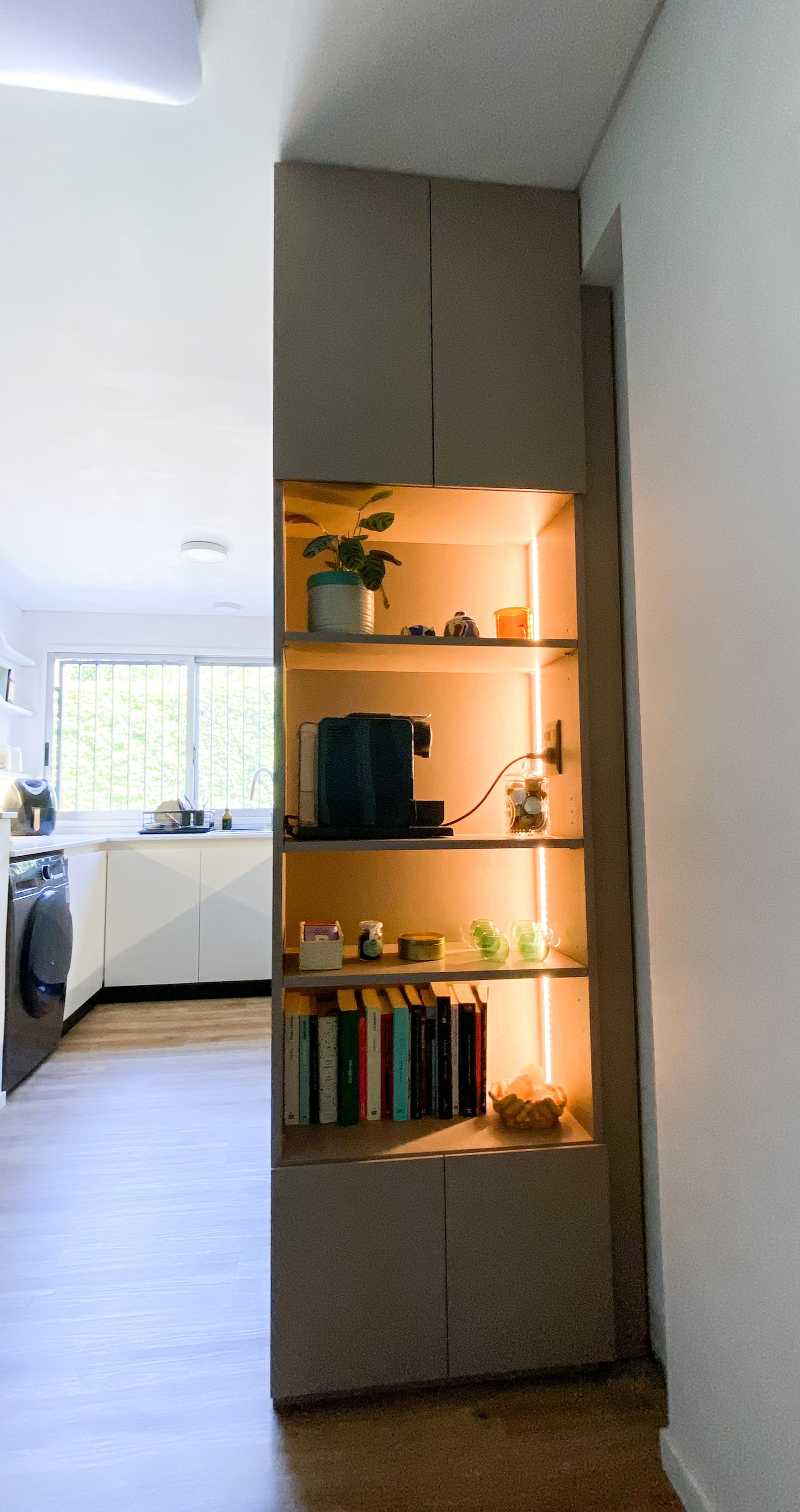 Cozinha moderna com armários modulares integrados e prateleiras iluminadas — projeto Proyecto Quesada, por Arq.Flor Landsman, em Coghlan