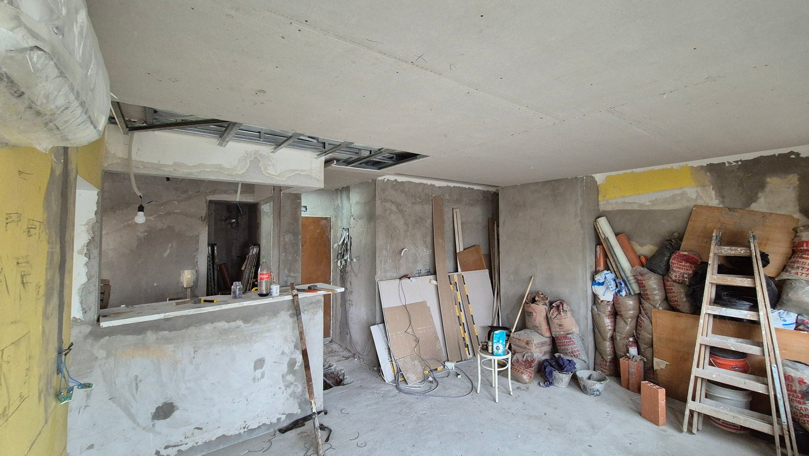 Espacio interior en obra con concreto expuesto y materiales de construcción — proyecto Living - Remodelación Soho, por RenovArqui, en Palermo