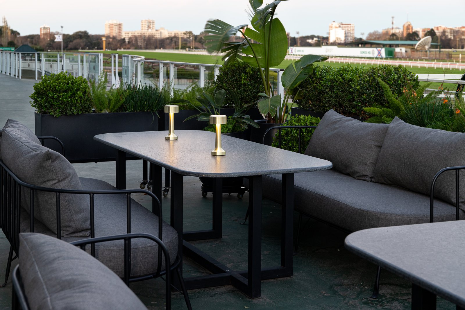 área externa moderna com móveis cinzas e pergolado — projeto PRESIDENTE BAR HIPODROMO, por AB ARQUITECTURA, em San Isidro