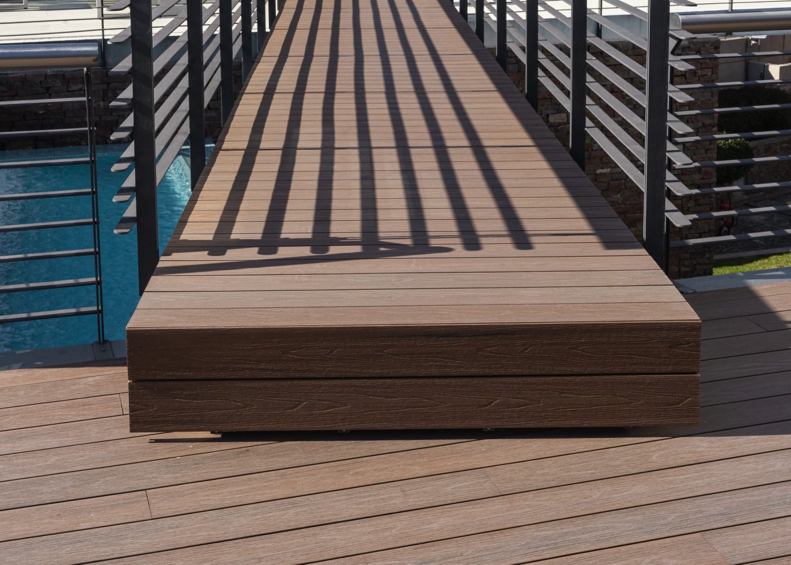 Detalle de pasarela de madera con sombras y barandas metálicas — proyecto Outdoor, por The Flooring Company