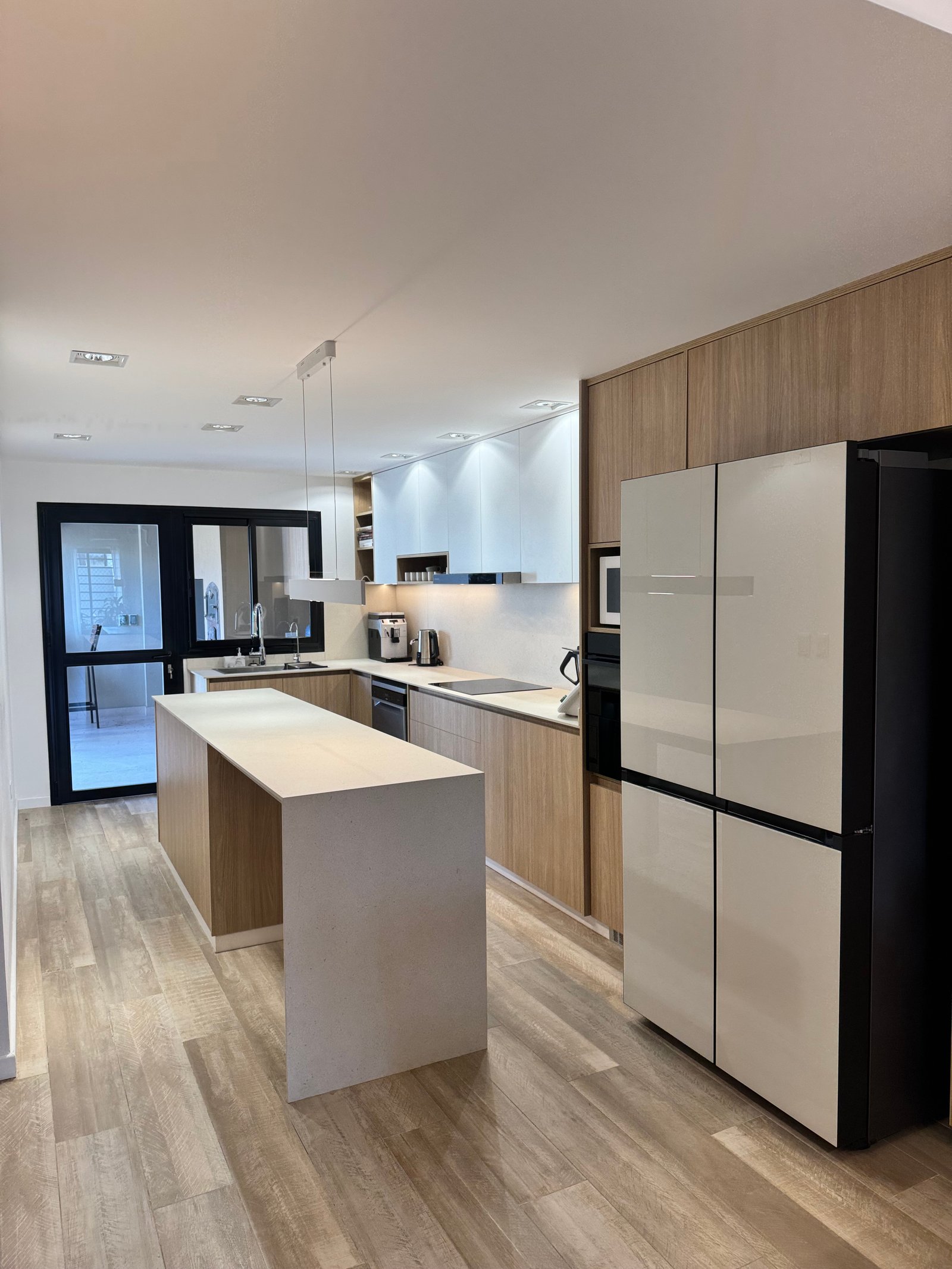 Cozinha moderna com ilha central e armários de madeira natural — projeto CASA LEAN, por Estudio Grupo 32, em Vicente López