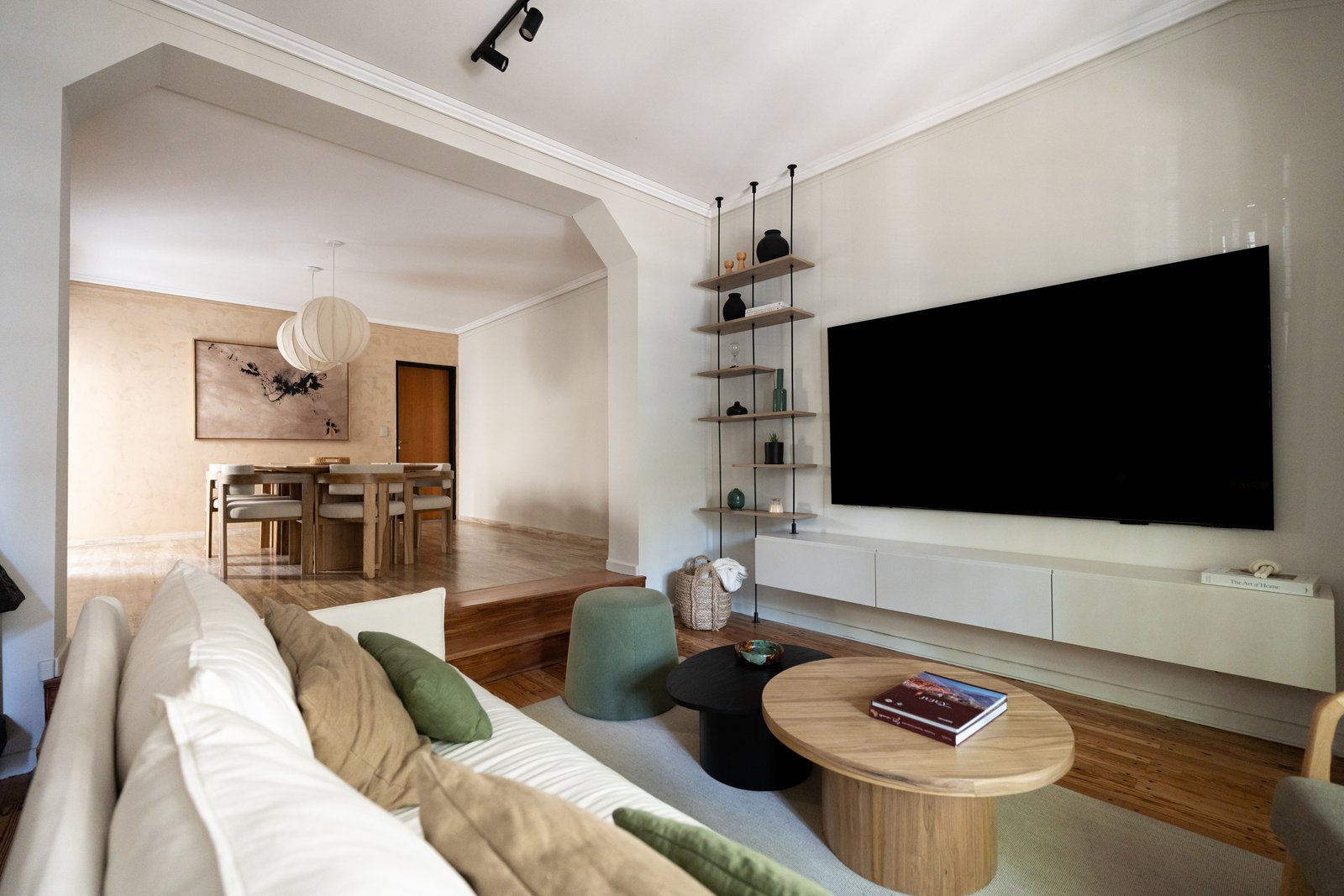 Sala de estar moderna com sofá curvo e sala de jantar integrada — projeto Felipe Vallese, por Estudio BDM, em Flores