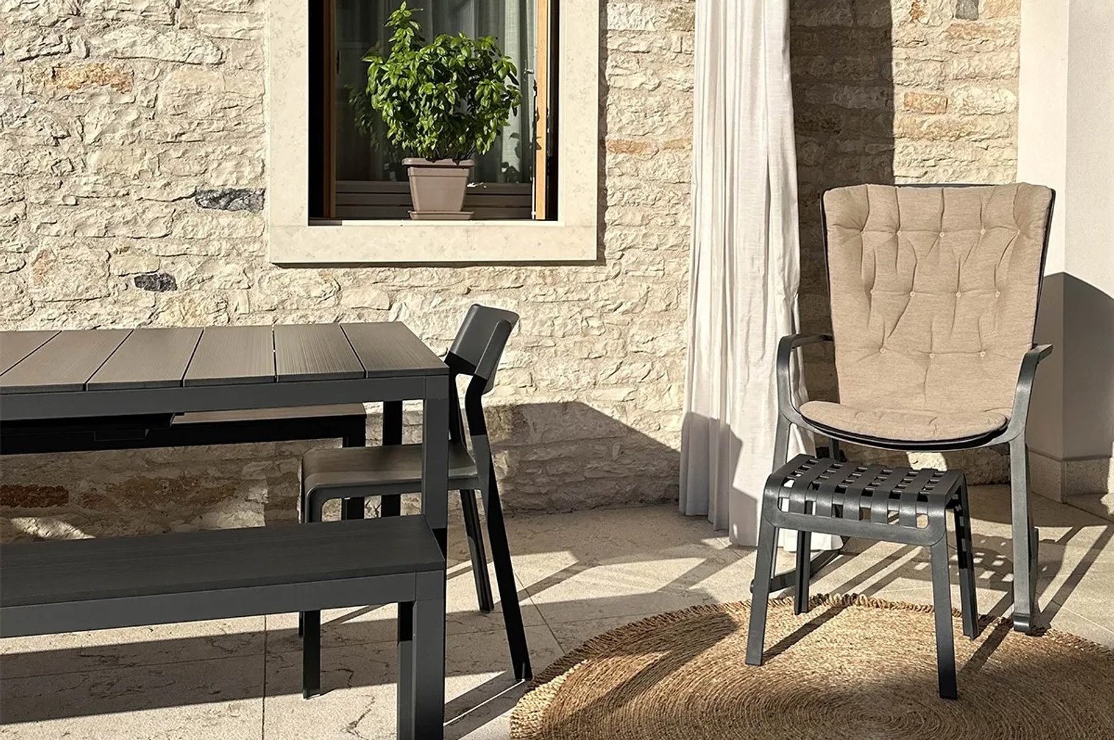 Pátio moderno com conjunto de jantar e parede de pedra — projeto Living Exterior, por Casa Nuñez