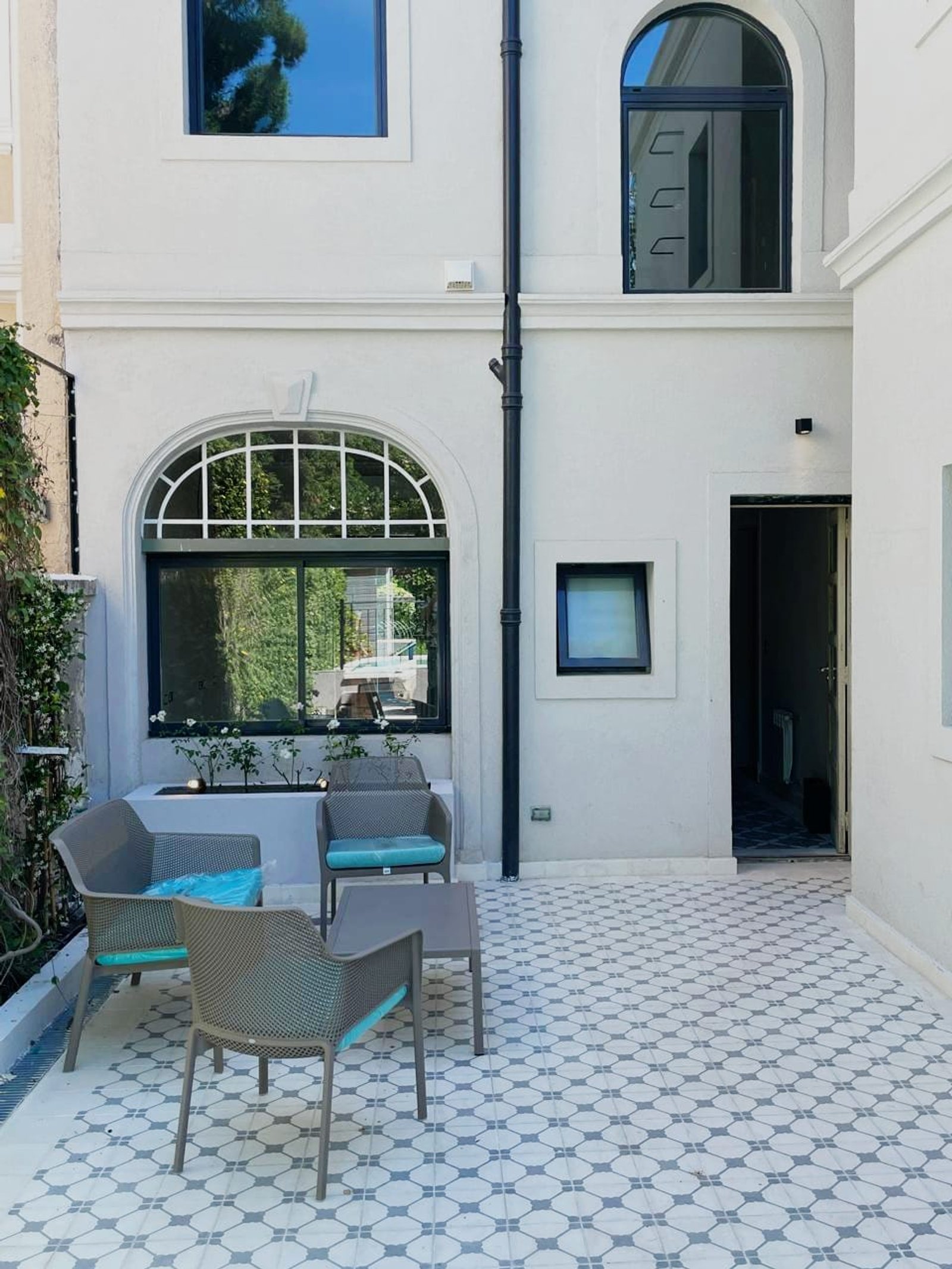 Pátio moderno com azulejos geométricos e móveis cinza — projeto Living Exterior, por Casa Nuñez