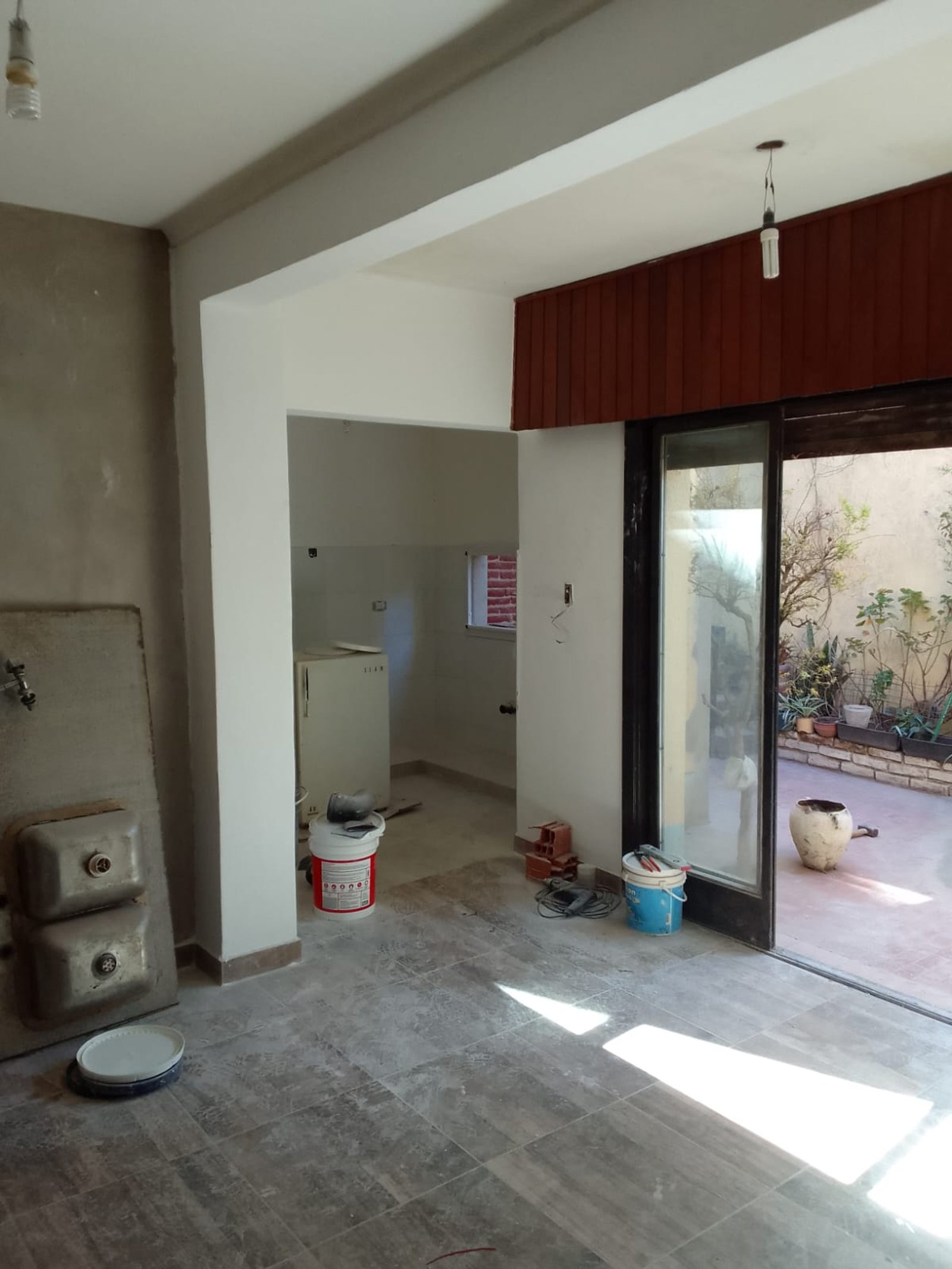 Cocina en construcción con pisos de piedra y paneles de madera — proyecto 2 Casas en Lanus, por Arquitecto Guido Niccoli, en B1824 Lanús