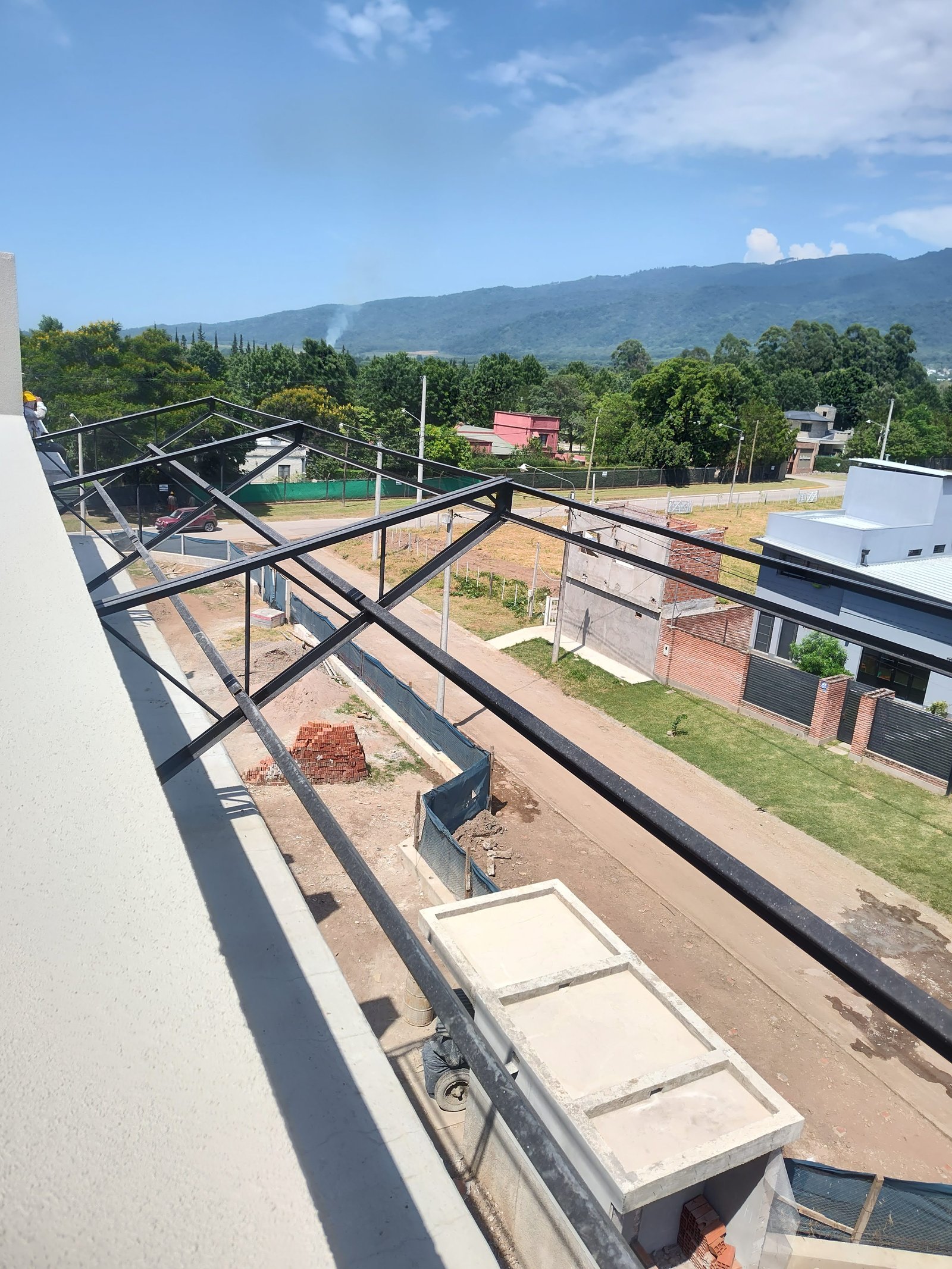 Fachada moderna en construcción con estructura metálica — proyecto EDIFICIO CHUBUT, por HMCONSTRUCCIONES, en Chubut