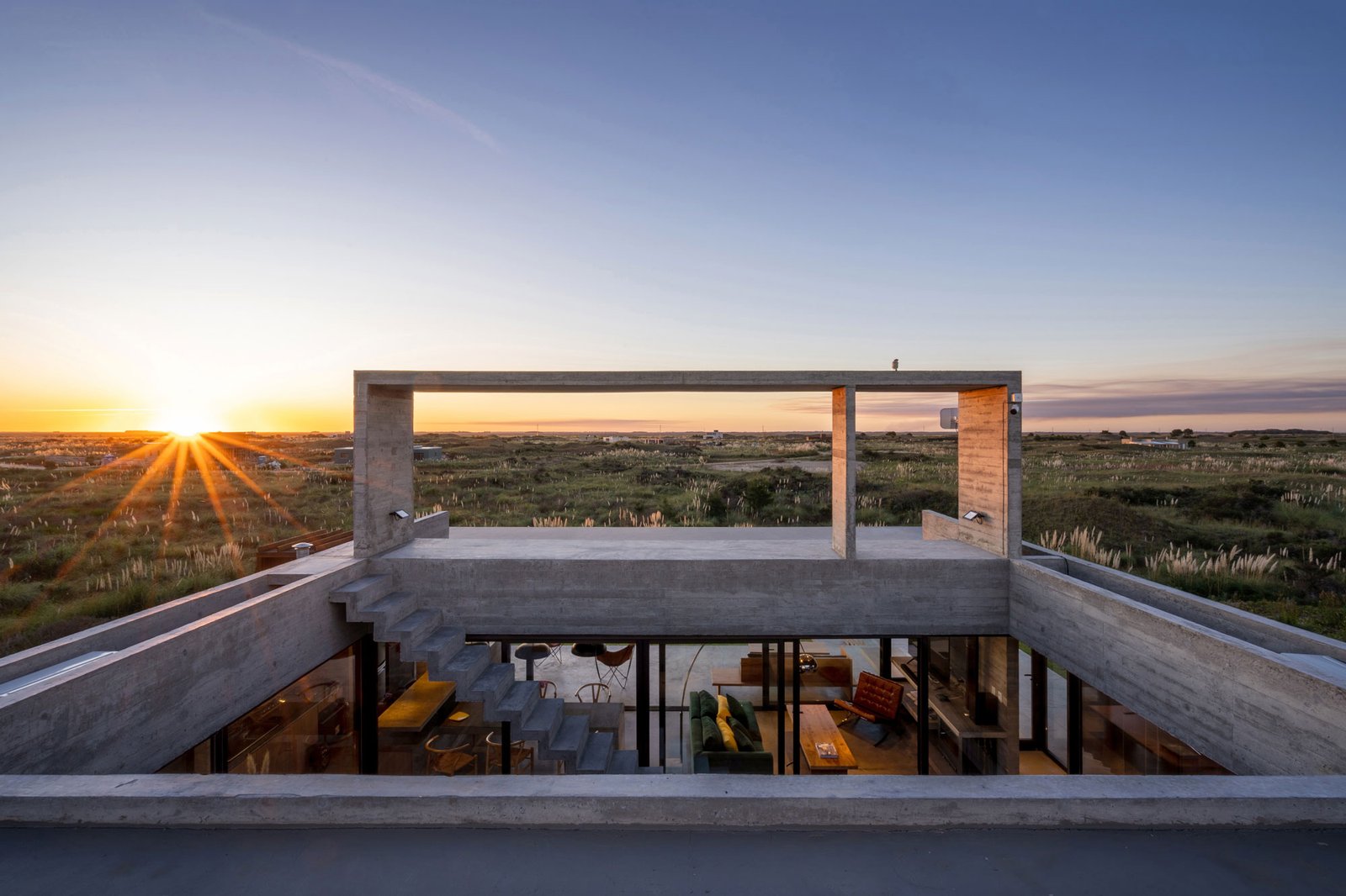 Casa moderna de hormigón con vista al atardecer — proyecto Casa Médanos, por Besonías Almeida arquitectos, en JWRC+MQ
