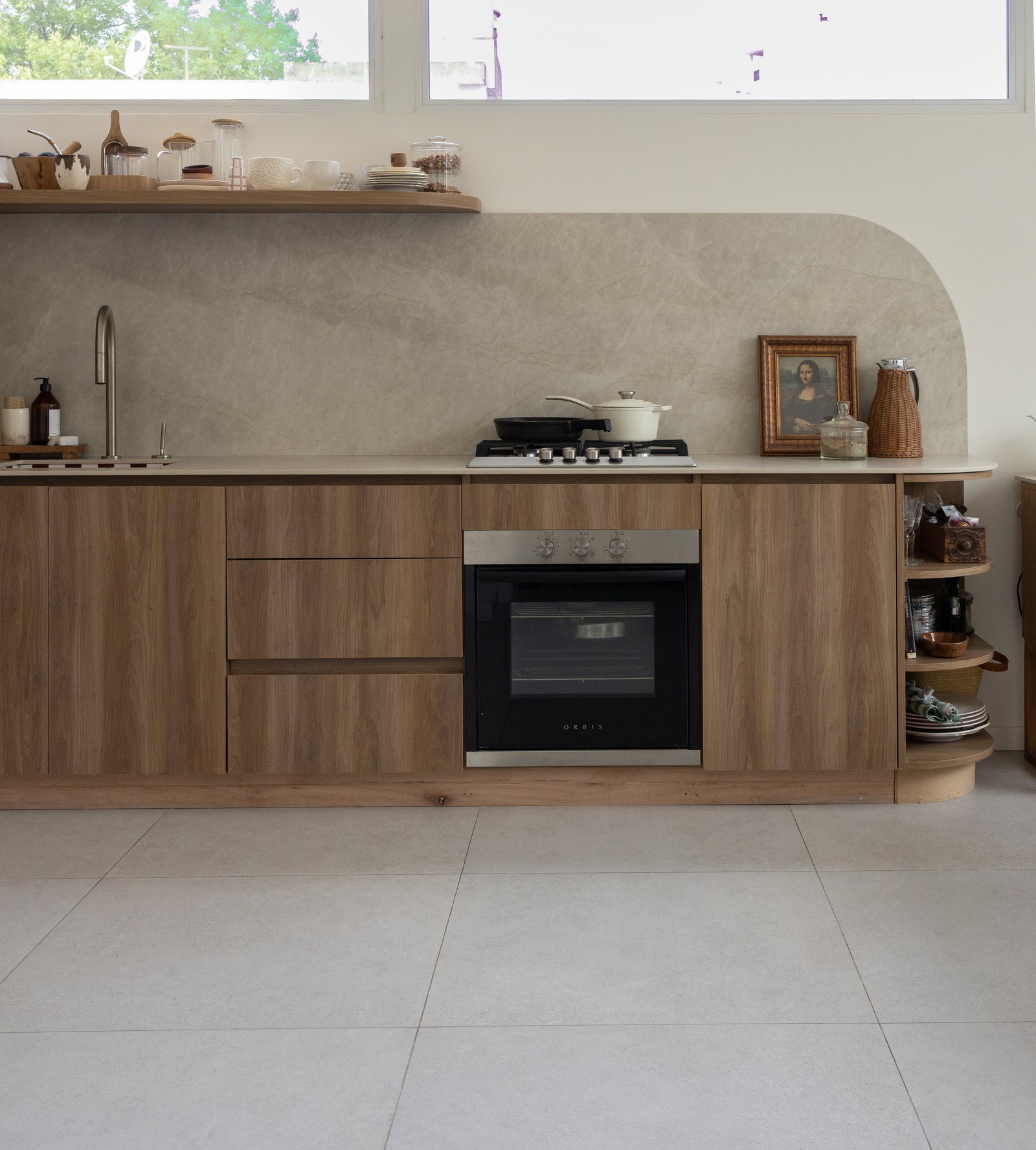 Cozinha moderna com armários de madeira e parede curva — projeto Flor Lamas, por San Lorenzo Design, em Zelada 4488
