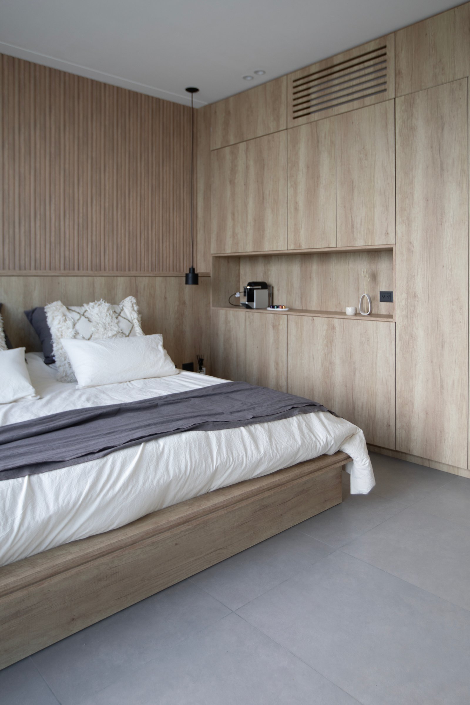 Dormitorio moderno con paredes de listones de madera y armarios integrados — proyecto CASA TRIBECA CONCRETE BROADWAY, por ILVA, en Provincia de Buenos Aires