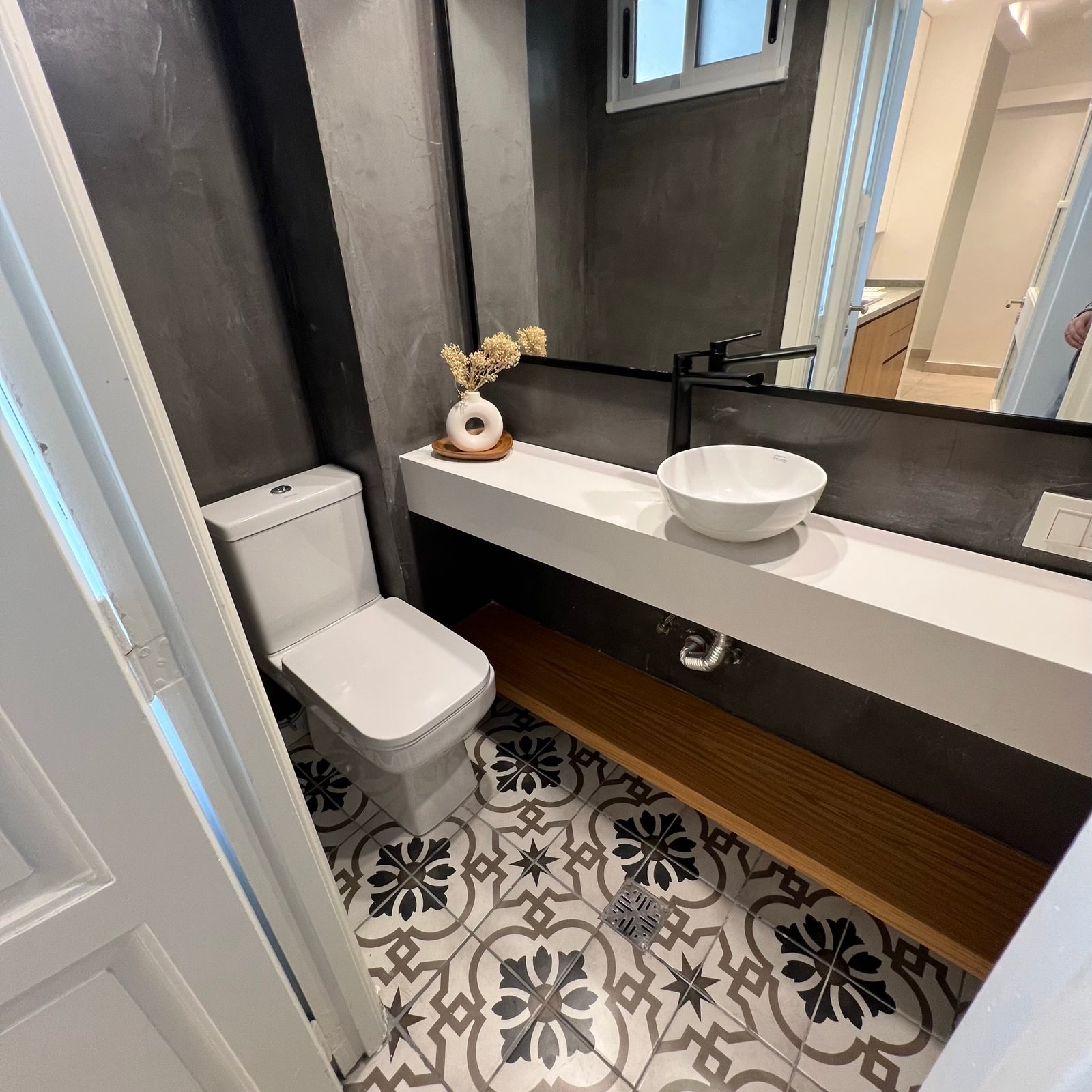 Baño moderno con mosaicos geométricos y pared de microcemento — proyecto Perón , por MDBK Arquitectura, en Barrio Norte