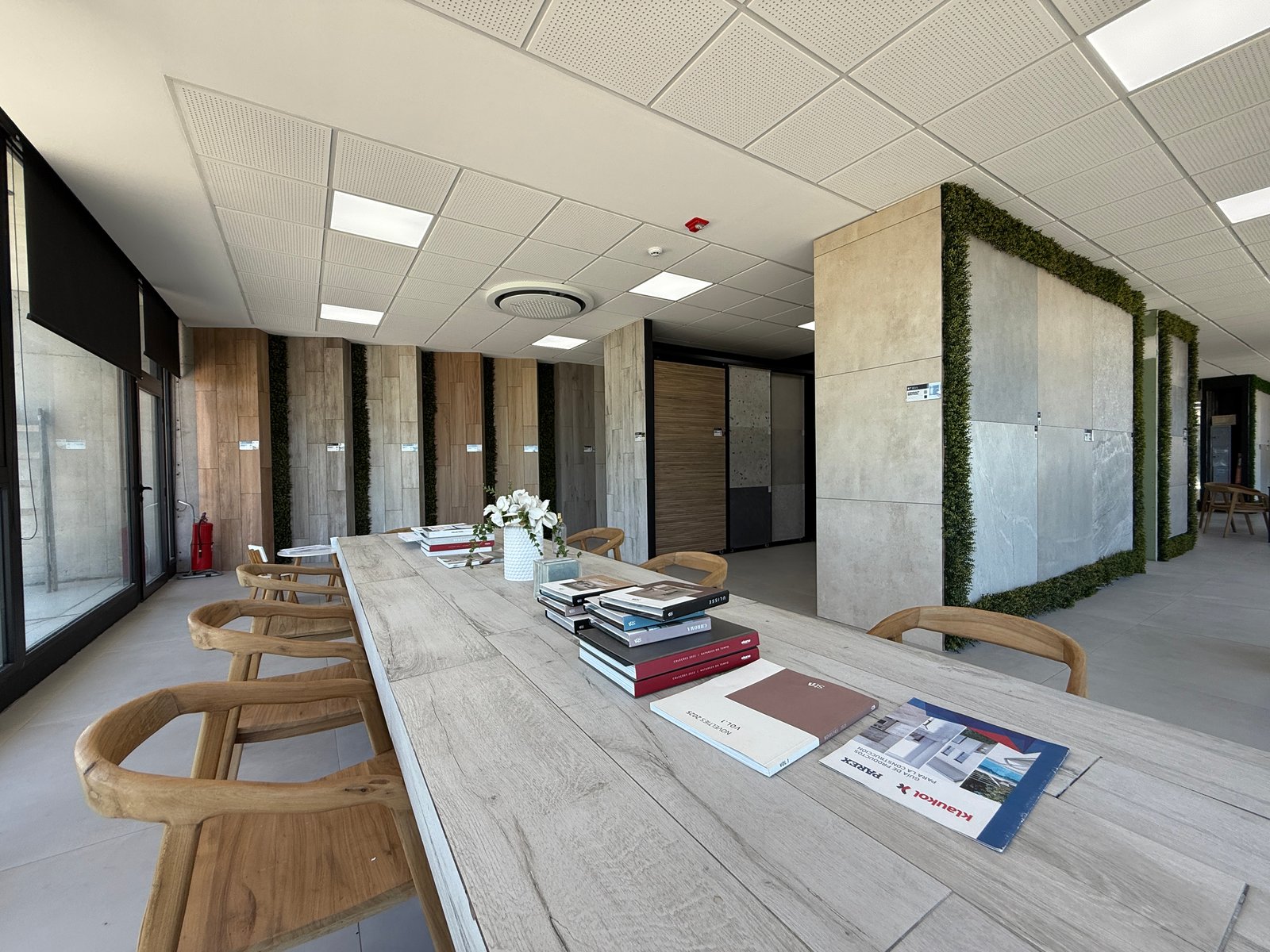 Sala de reuniões moderna com mesa de madeira e cadeiras cinzas — projeto Showroom, por GAP HAUS, em Calle Austria Nte. 2450