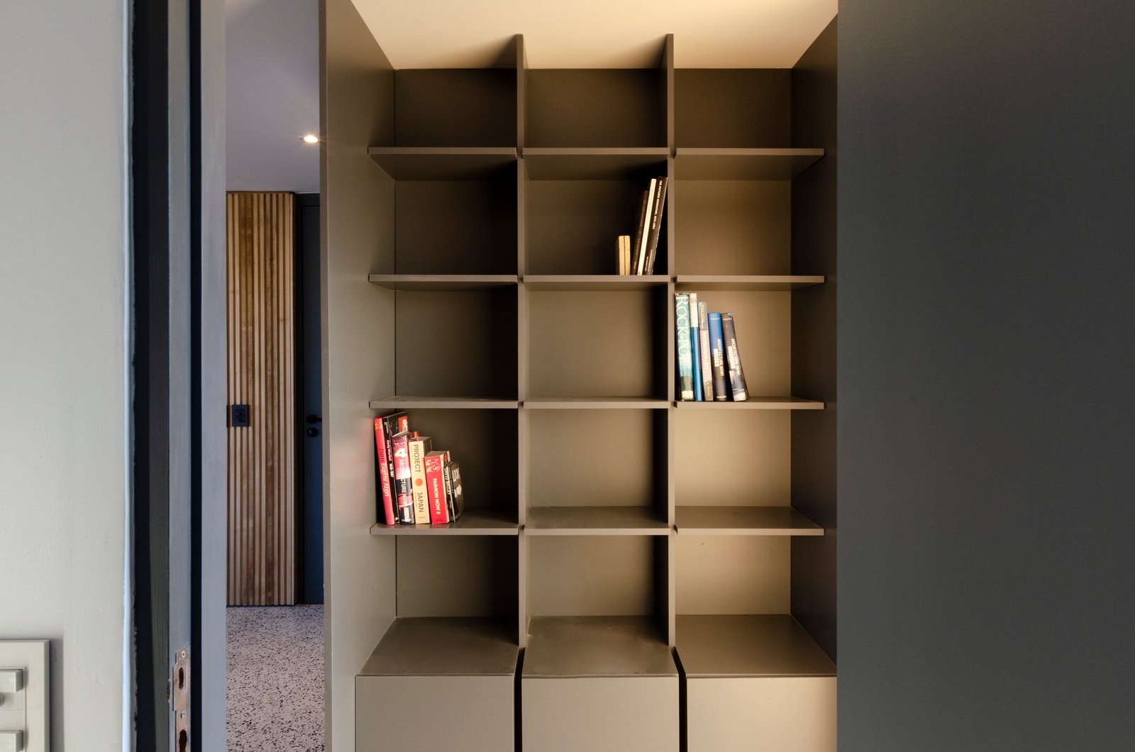estante modular cinza em corredor minimalista — projeto Guayra - Andrea Gonzales, por ABEJA CONCEPT, em Belgrano