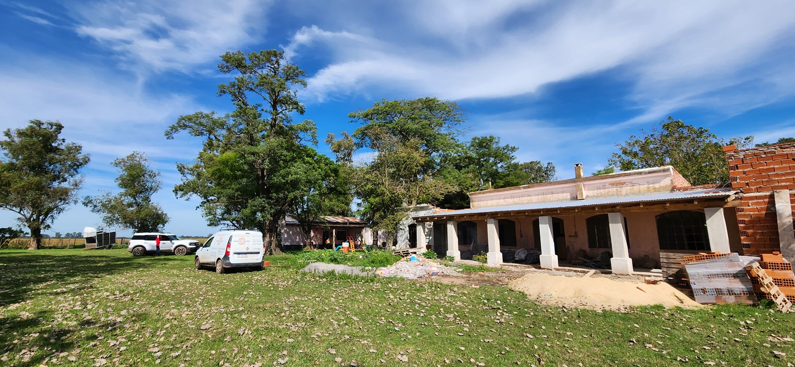 Fachada rural en construcción con arcos y vista al campo — proyecto Casa WAI, por Estudio Rifahi, en Zenón Videla Dorna