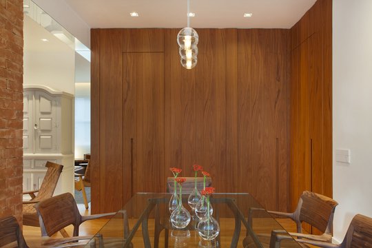 Comedor moderno con revestimiento madera, mesa y sillas de diseño, pendiente vidrio — proyecto MS House, por Studio Ro-ca