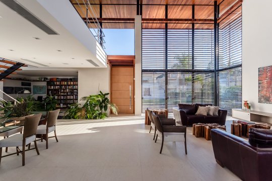 Living contemporáneo con doble altura, grandes ventanales y plantas — proyecto Casa E.H., por Ruschel Arquitetura e Urbanism
