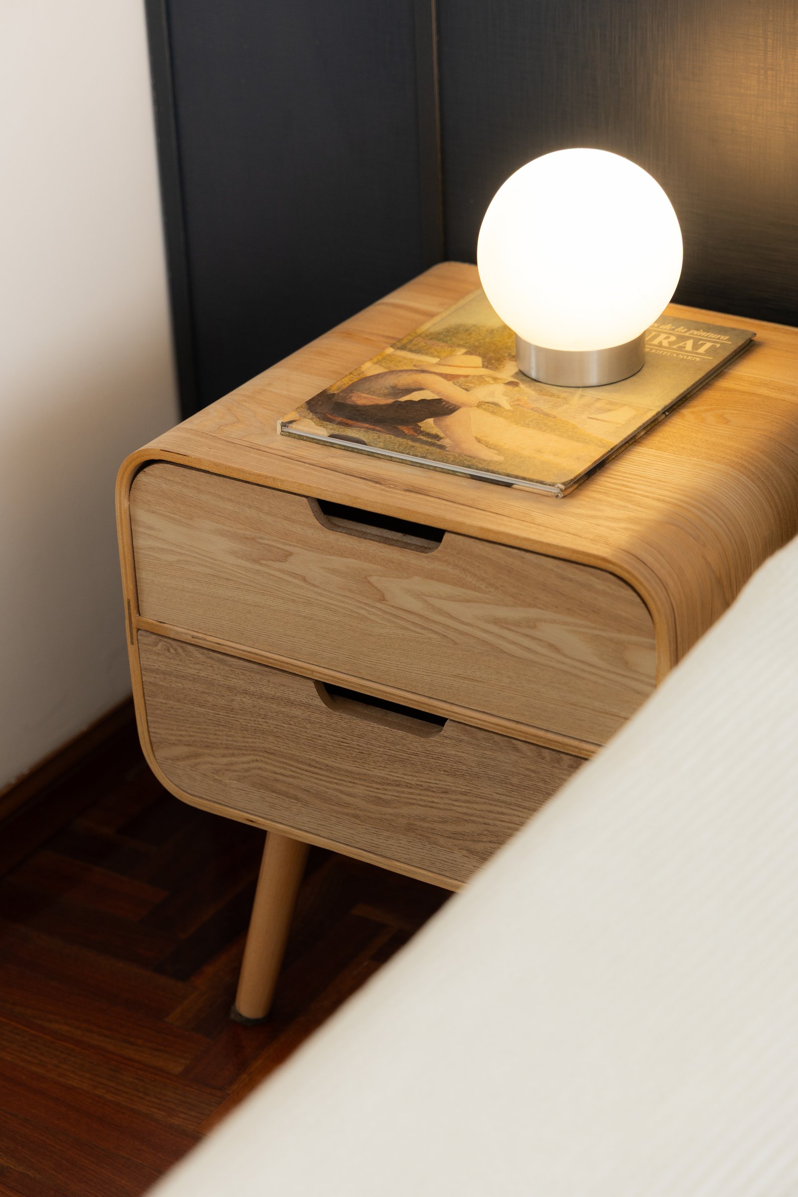 Mesa de noche moderna de madera con lámpara esférica — proyecto Arcos, por cromo., en Belgrano
