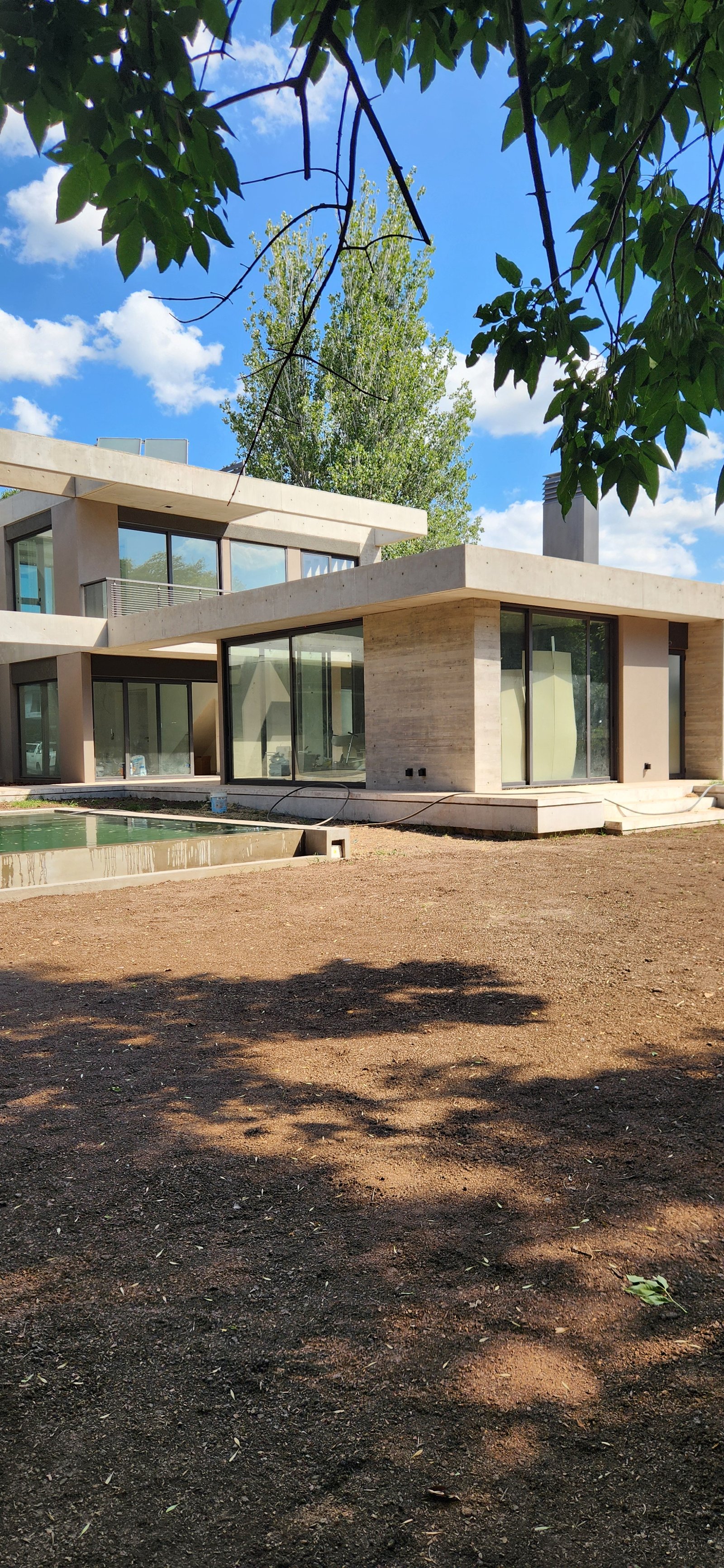 Casa moderna con piscina y grandes ventanales de hormigón — proyecto Casa CAD, por Estudio Rifahi, en Moreno