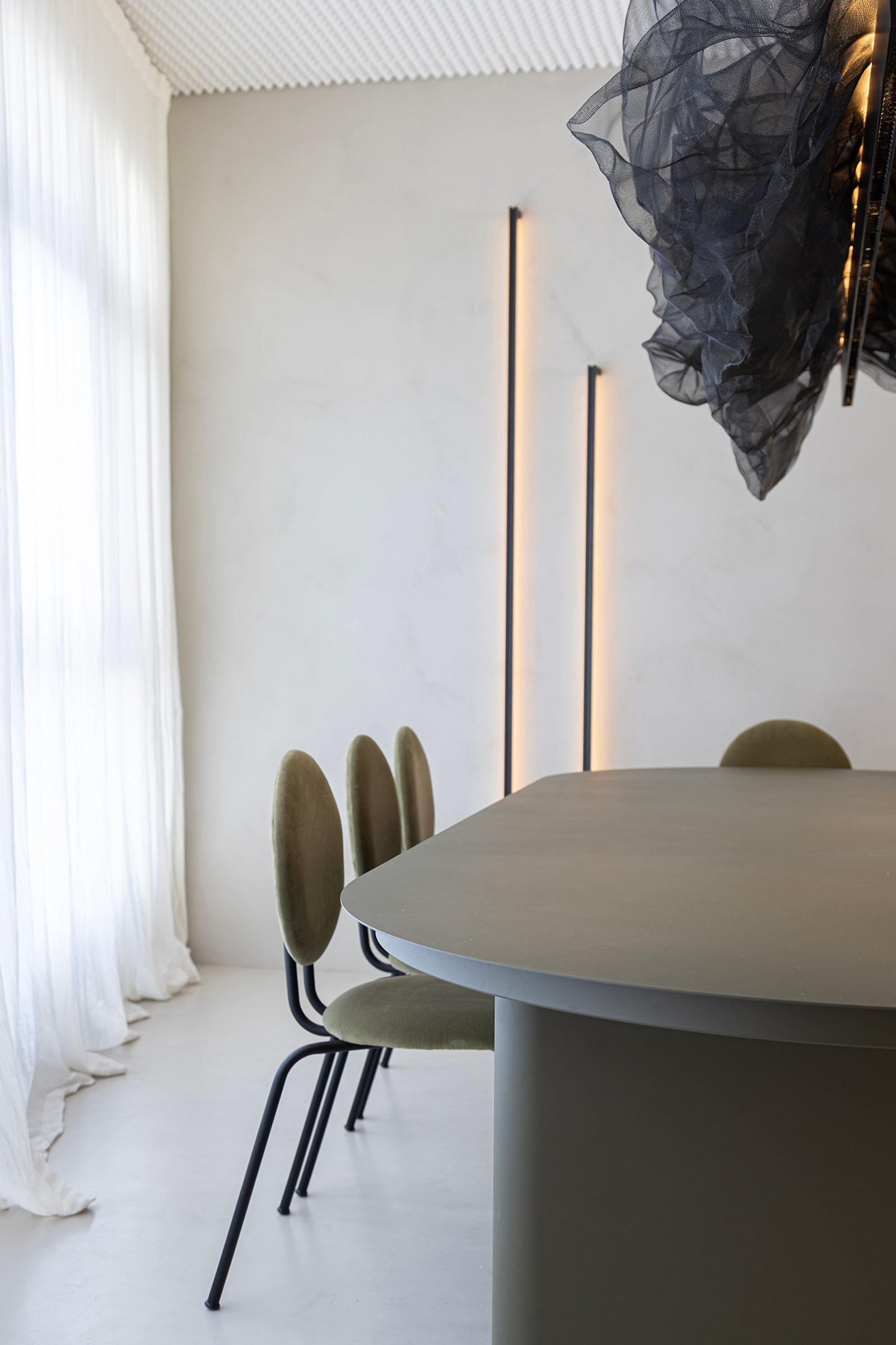 Comedor moderno con mesa ovalada, sillas verdes y cortinas blancas — proyecto HATSU Núñez - MZV Arquitectura, por Gaby Alfonso, en Buenos Aires