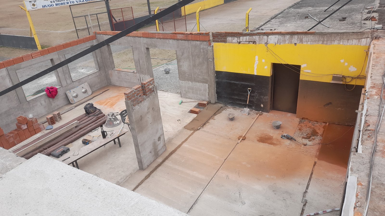 Espaço comercial em construção, paredes de concreto aparente e amarelo — projeto Remodelación Bodegón del depo, por CN Construcciones, em Alta Gracia